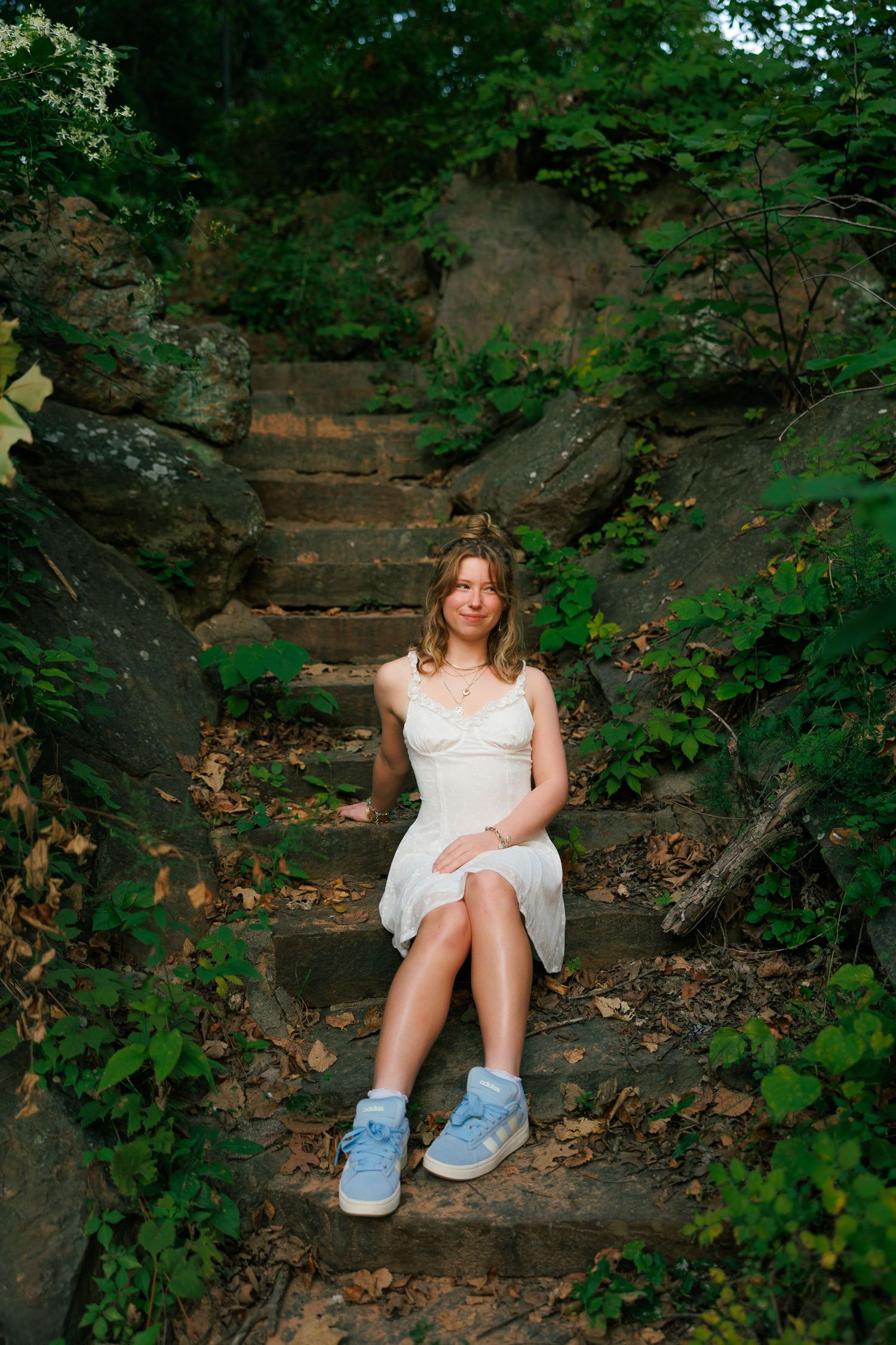 Portrait series on rustic stone steps surrounded by lush green foliage.