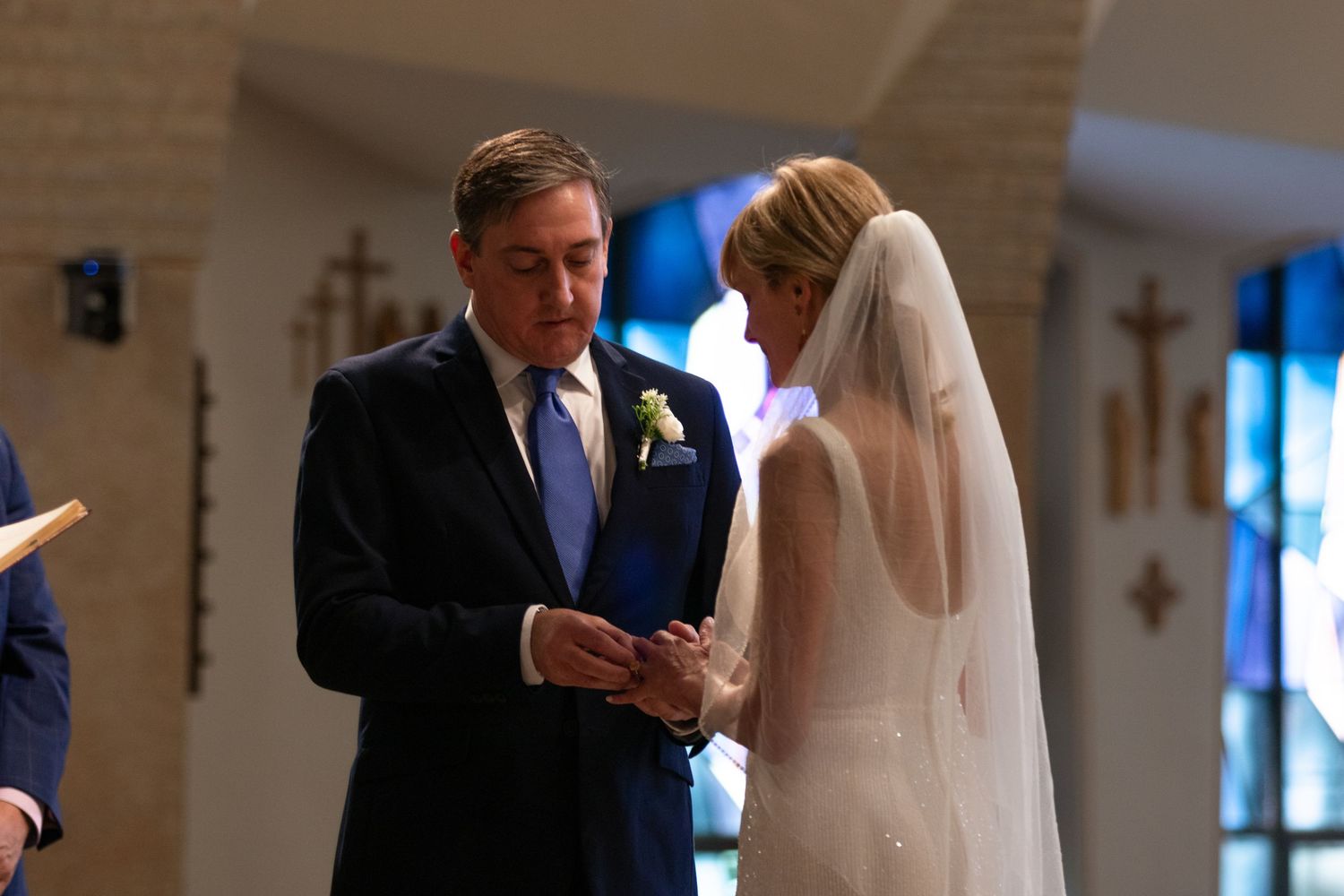 A wedding ceremony takes place in a traditional church setting.