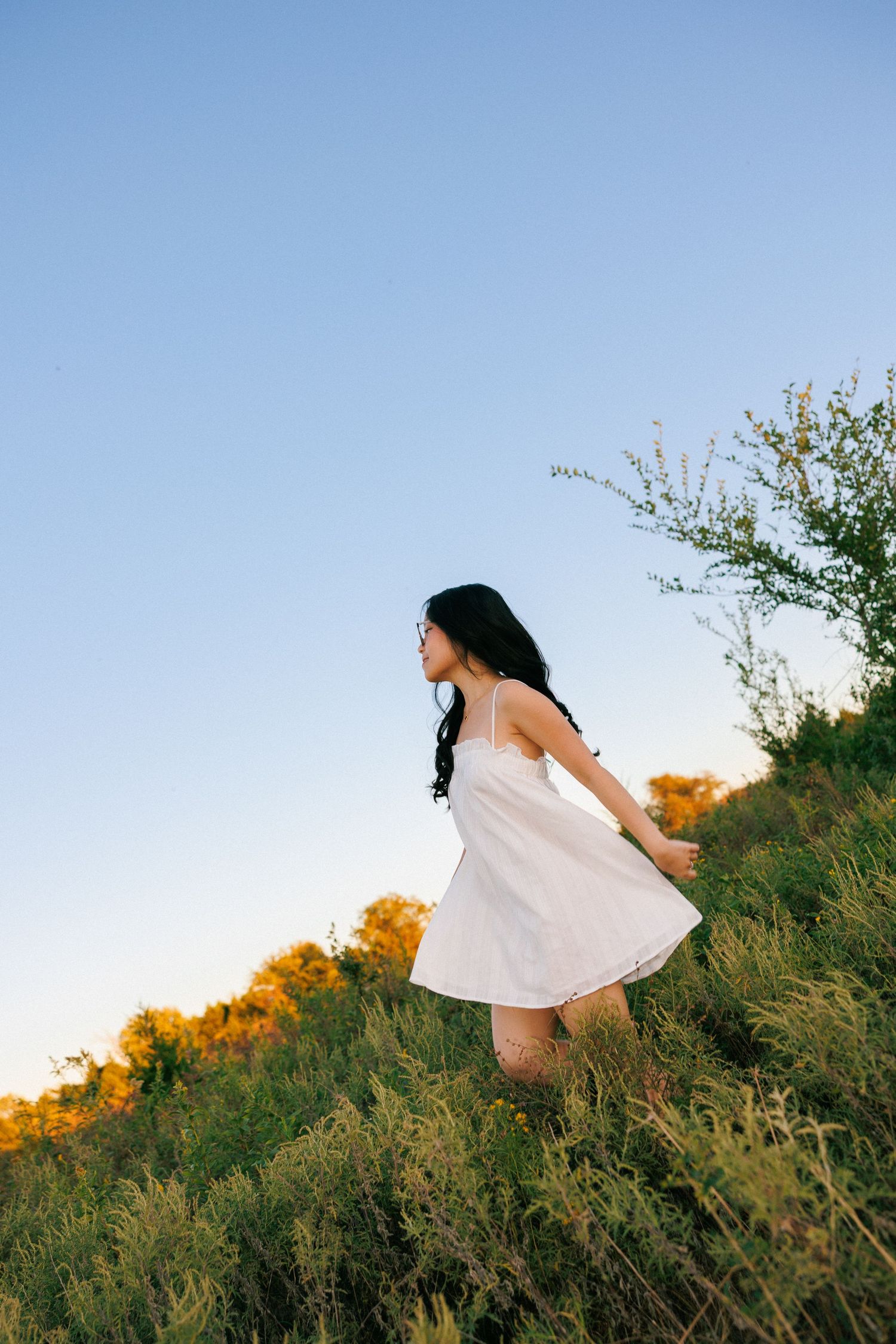 A flowing white dress captured against a hillside during golden hour.