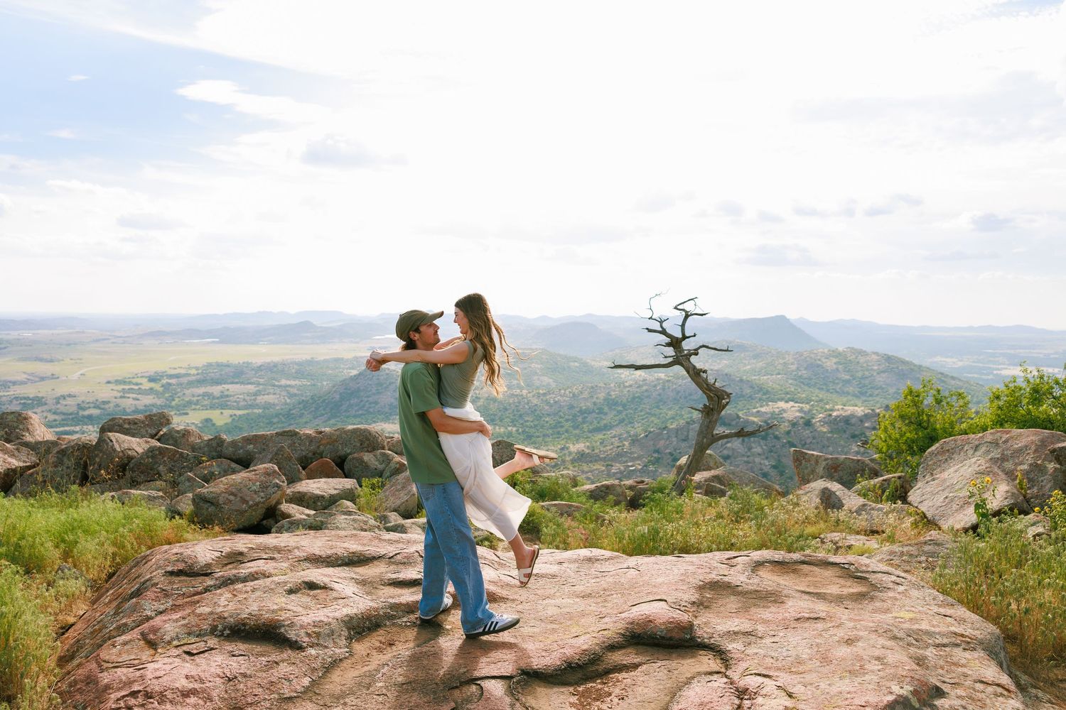 A scenic mountain overlook with dramatic views of rolling hills and valleys in the distance.