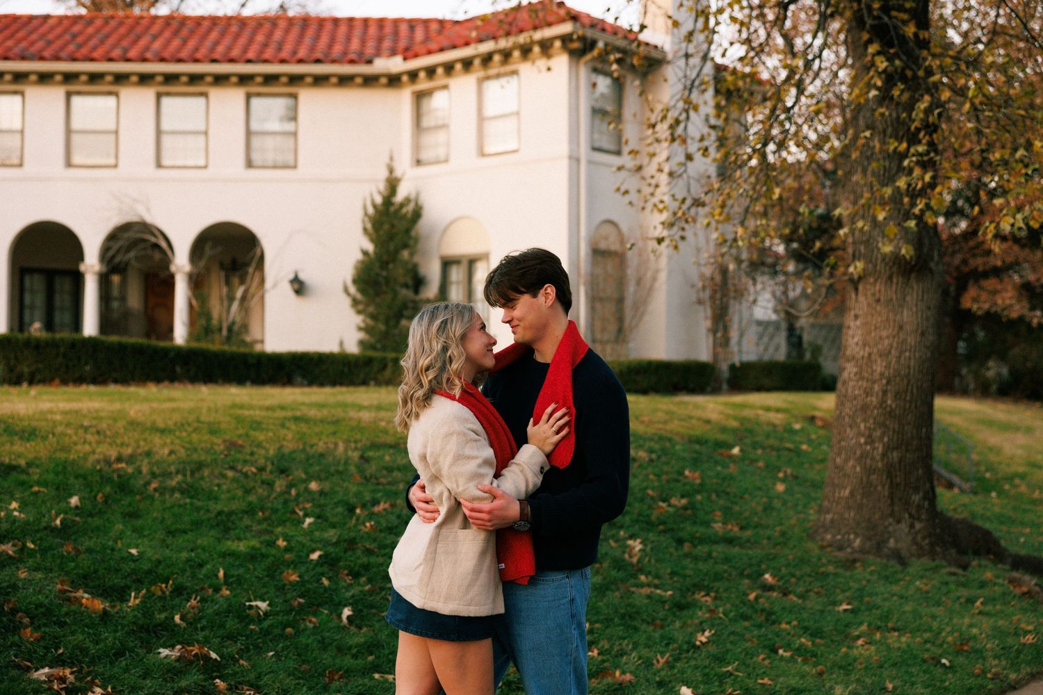 Autumn scene outside a white Spanish-style building with arched windows.