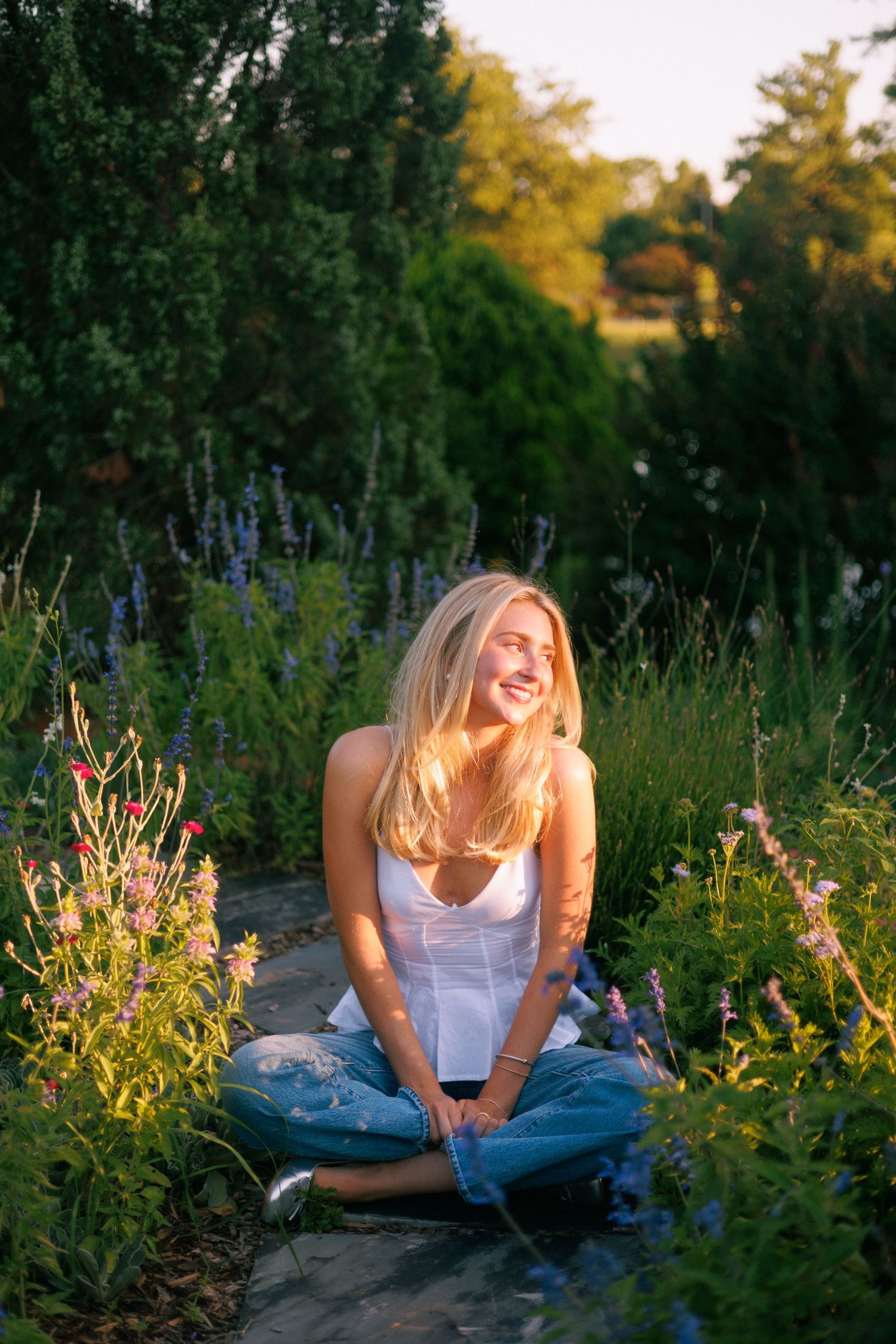 Casual summer portrait session in a wildflower garden during golden hour sunset.