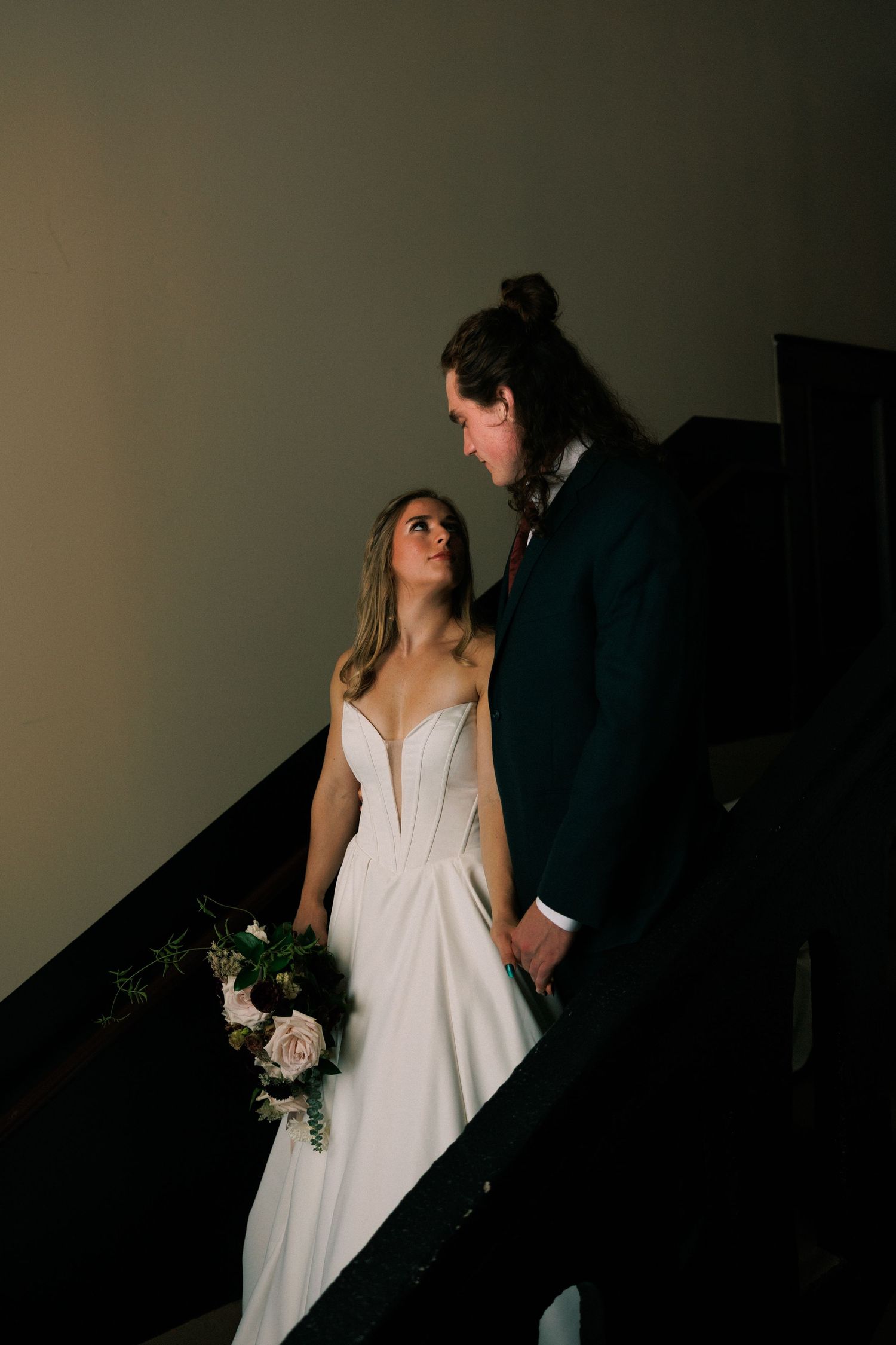 Artistic low-light wedding portraits in a minimalist setting.