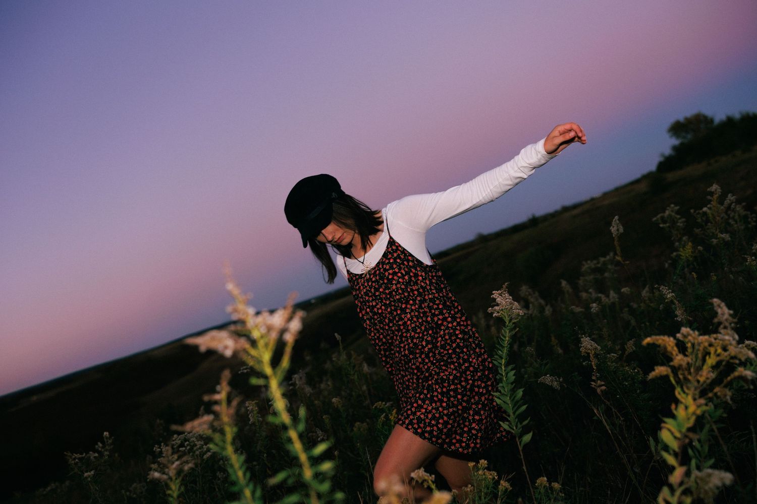 Dreamy purple sunset sky with silhouetted figures in a field.