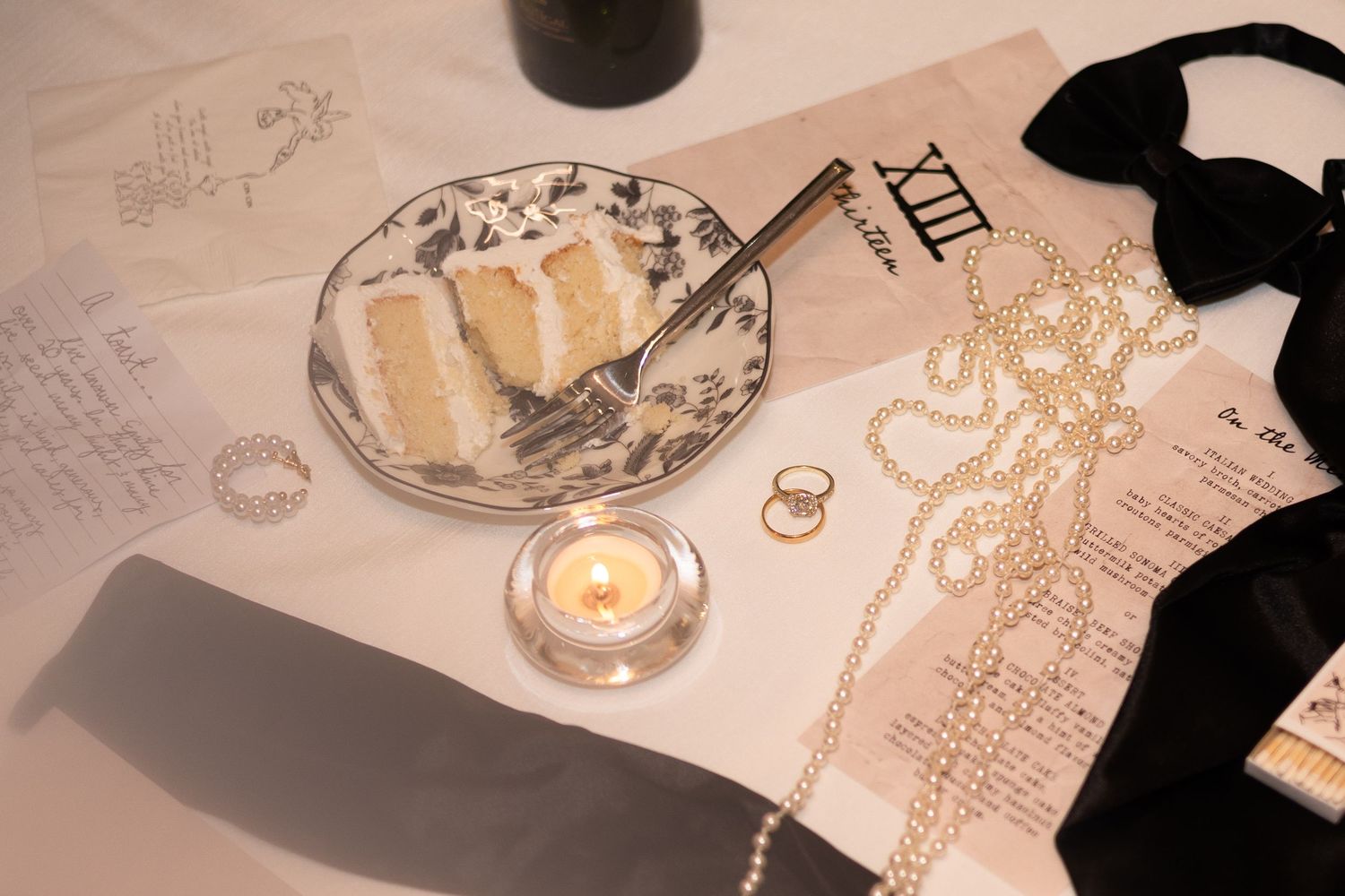 Wedding reception table details with candlelight and delicate place settings.