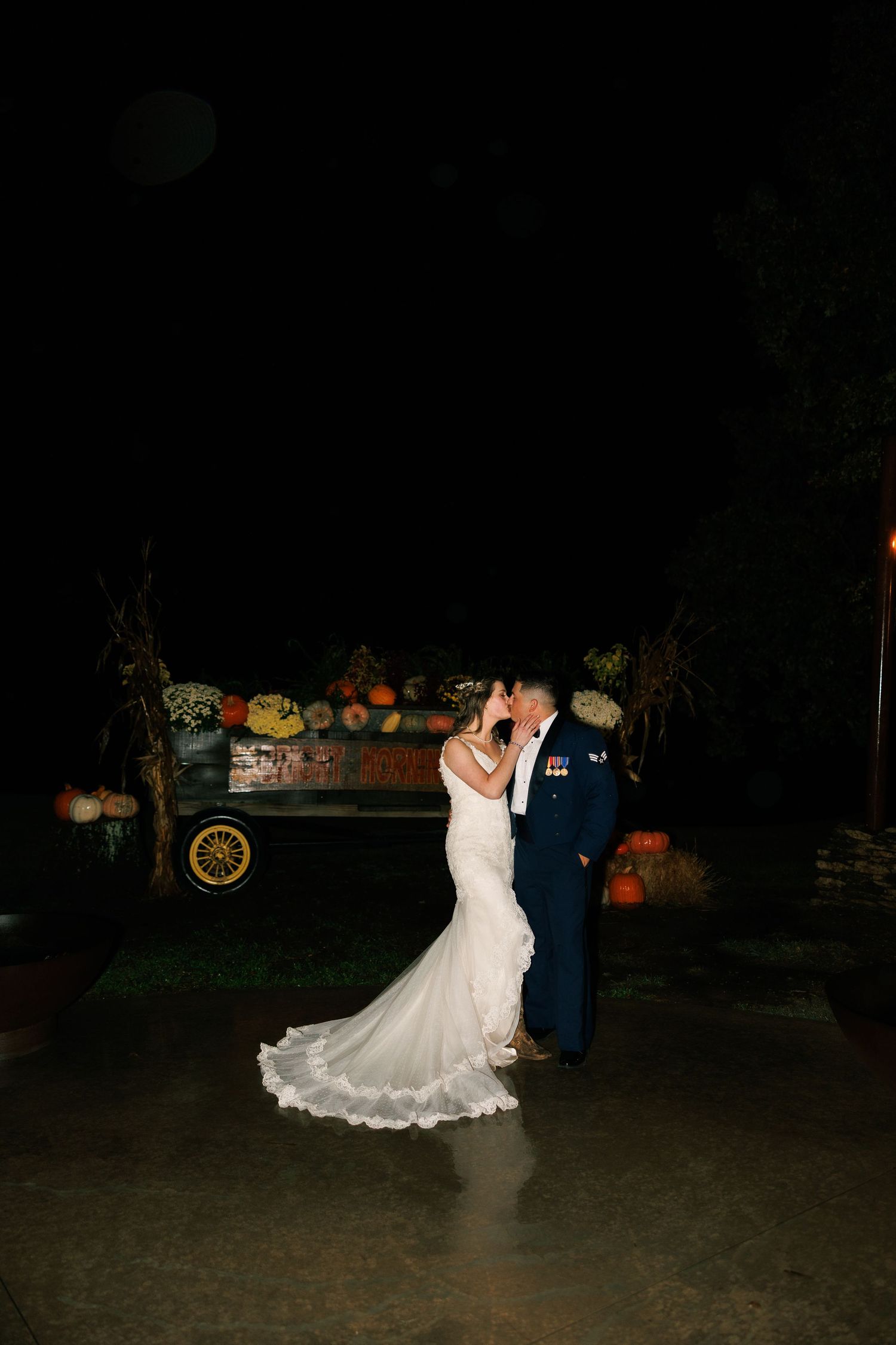 Couple dances at night with orange pumpkin decorations visible in background.