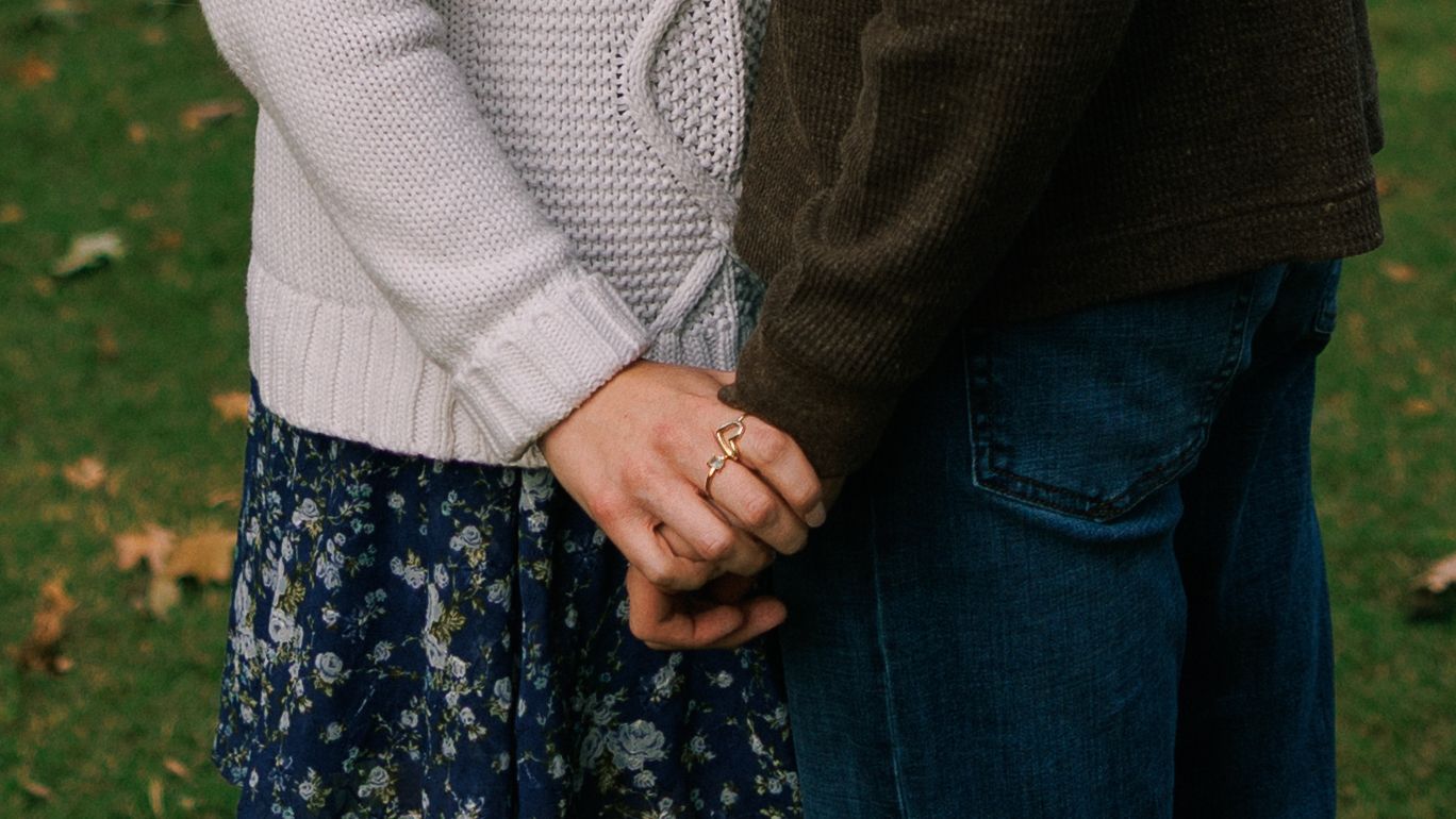 A casual autumn engagement photoshoot in a park with soft natural lighting.