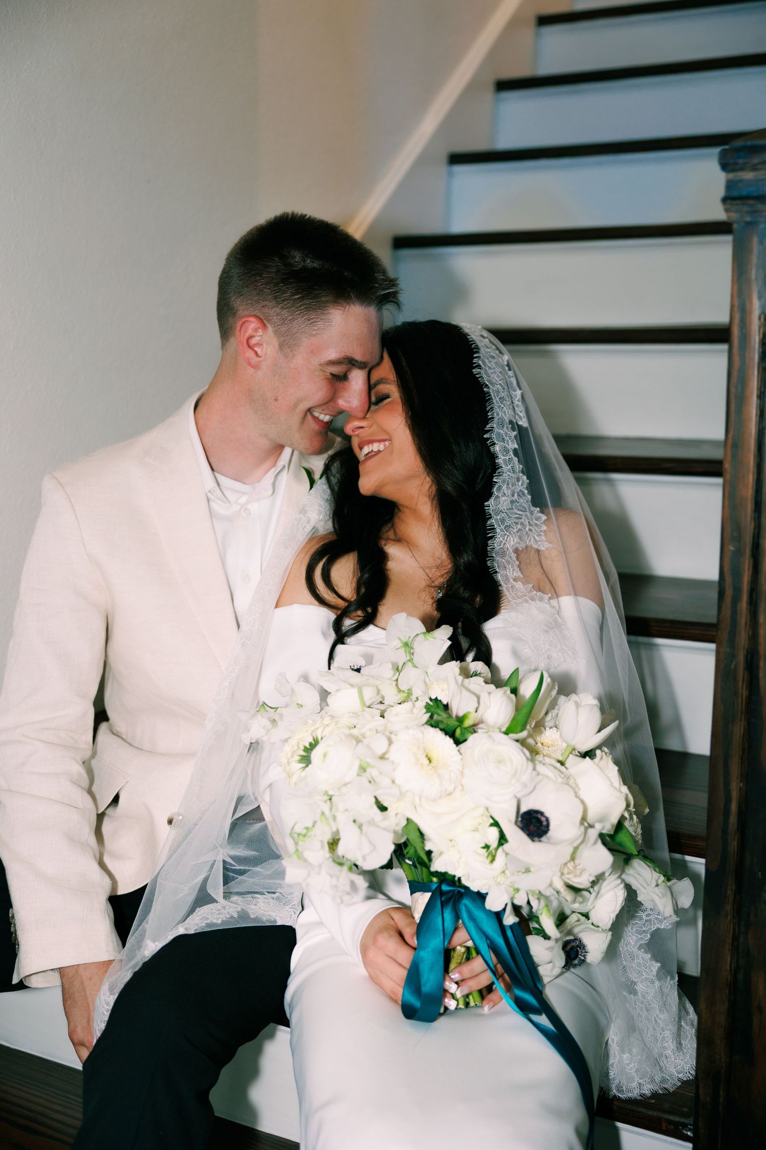 Intimate wedding portraits showing tender moments between newlyweds with white floral bouquet.