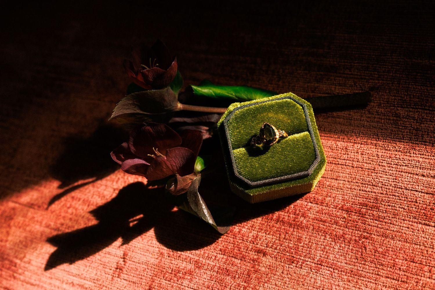 Wine bottles casting dramatic shadows on textured surface in warm lighting.