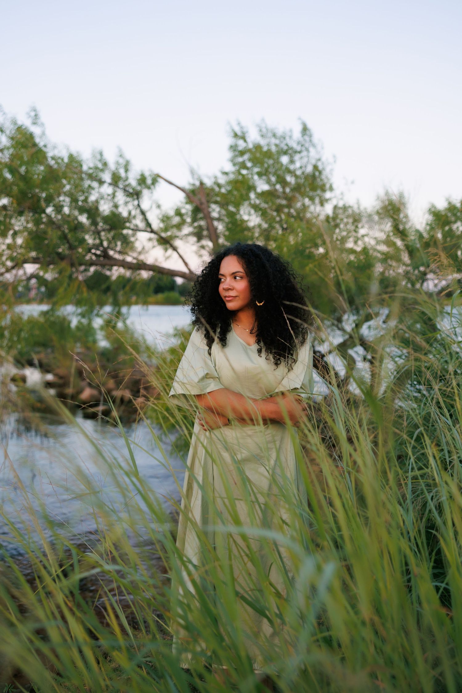 Tall grass sways by a lake during golden hour creating a dreamy natural scene.