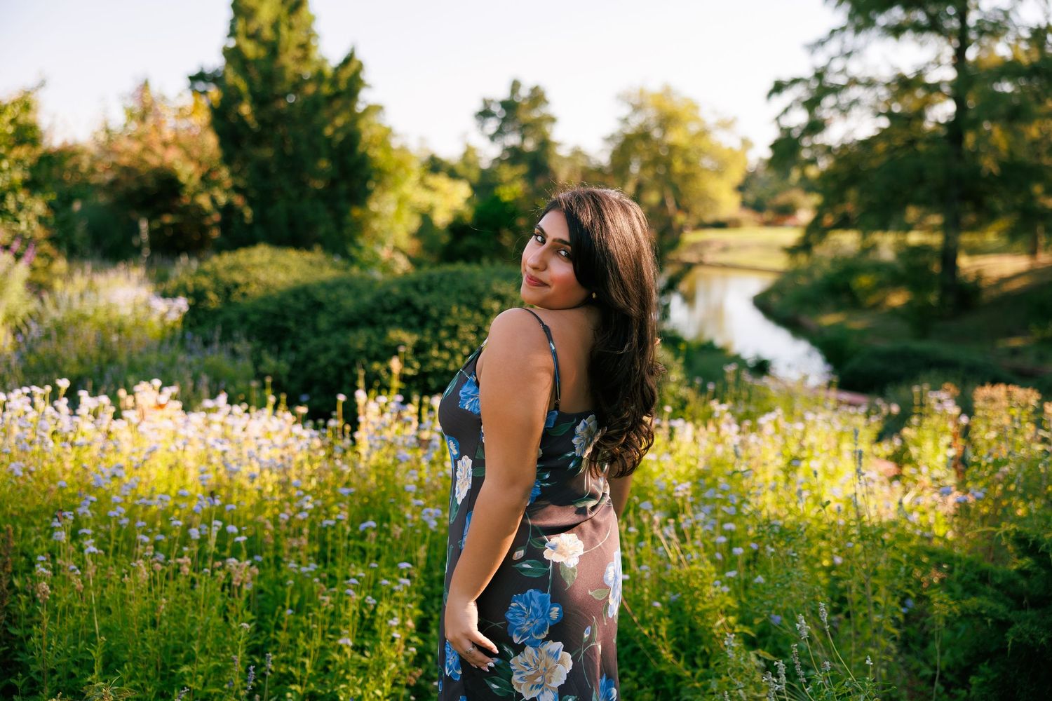 Person in casual outfit standing in wildflower meadow during golden hour.