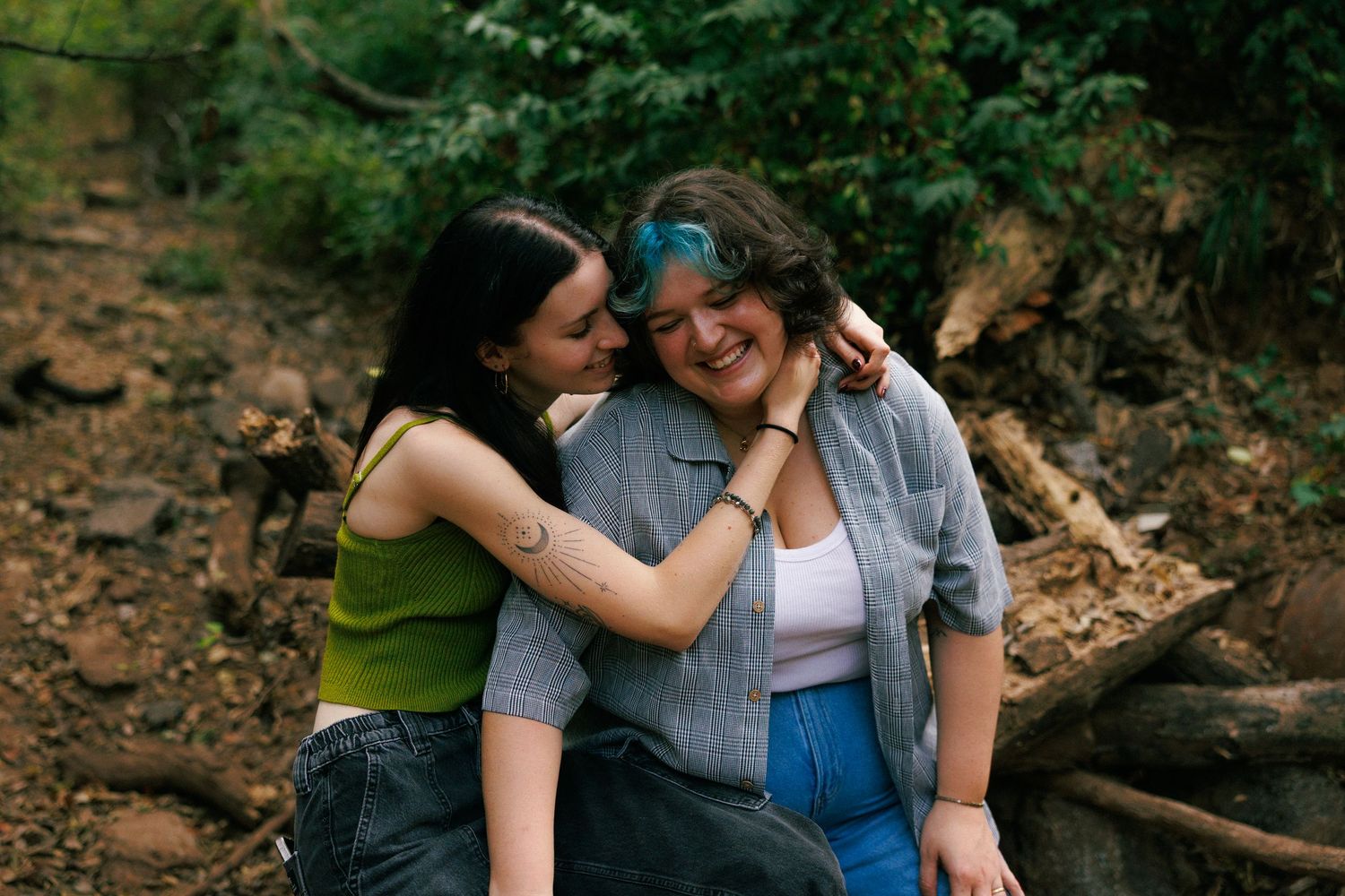 Couple sharing an intimate moment on rocky terrain during an outdoor photoshoot.