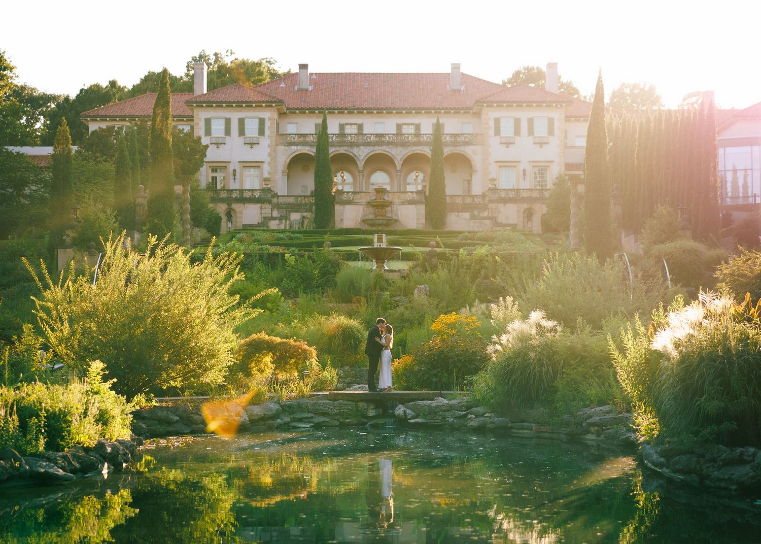A scenic panorama of a Mediterranean villa with gardens at golden hour.