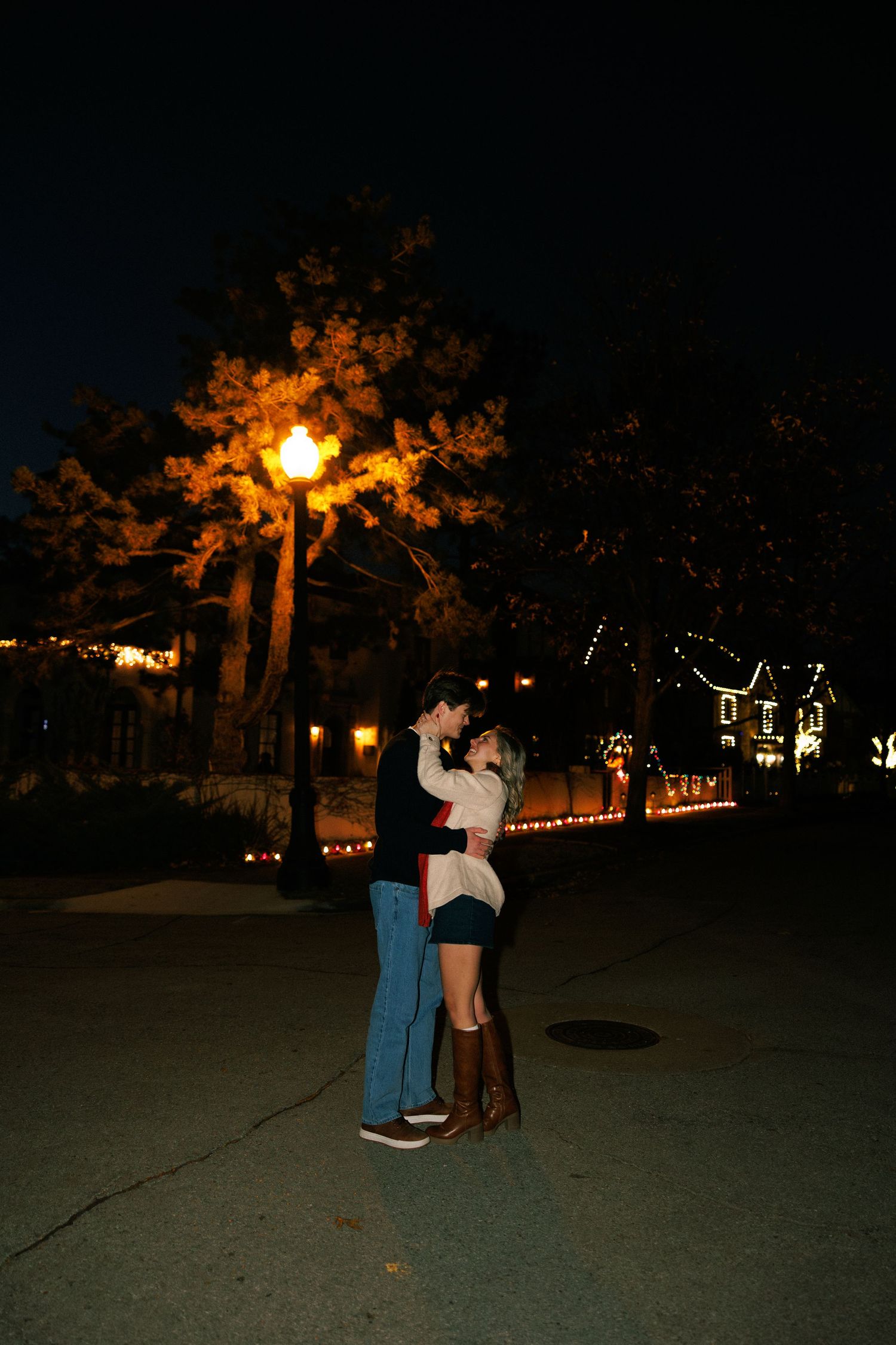 A nighttime scene with string lights and silhouettes in a park setting.