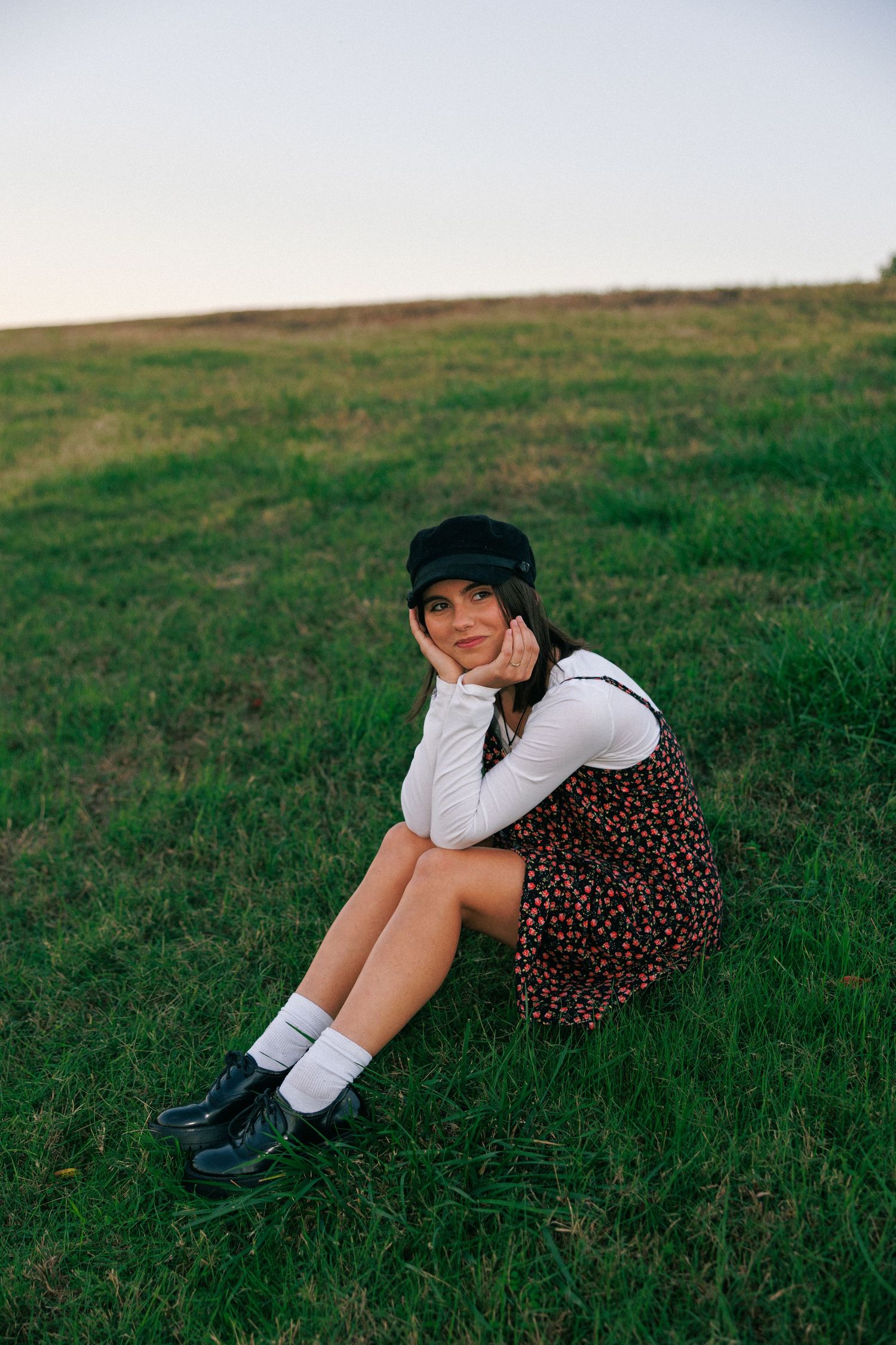 A pastoral scene with someone resting on grassy terrain wearing knee socks and boots.