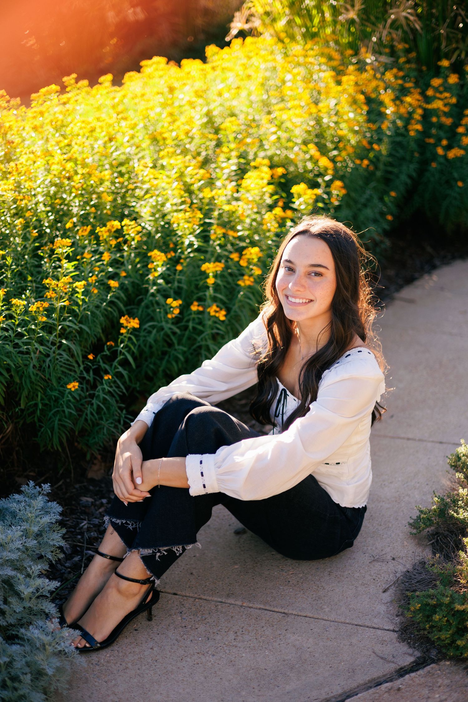 Fashion portraits with yellow flowers featuring white blouse and black outfit.