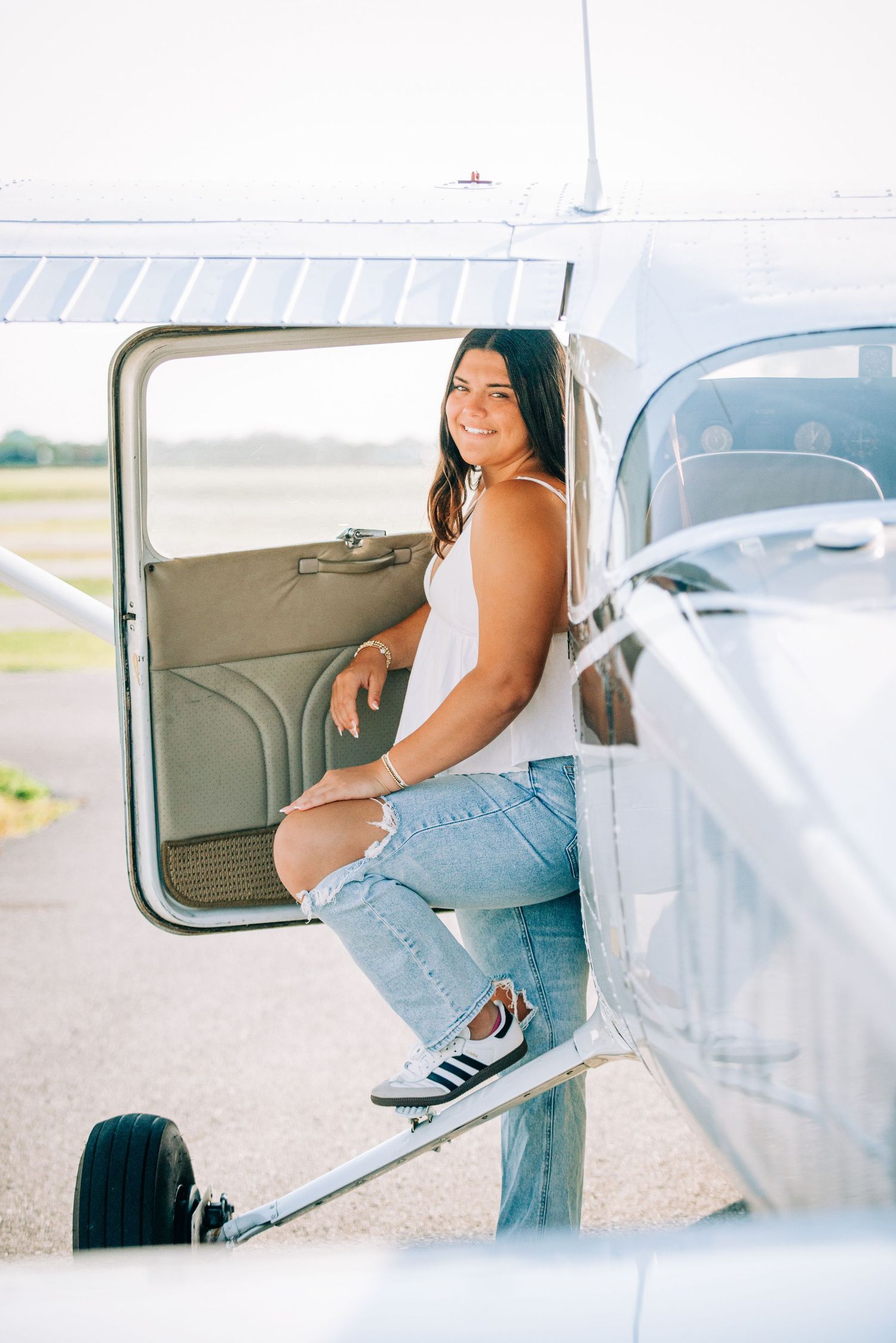 A series of casual poses taken inside a small aircraft during a sunny day photoshoot.