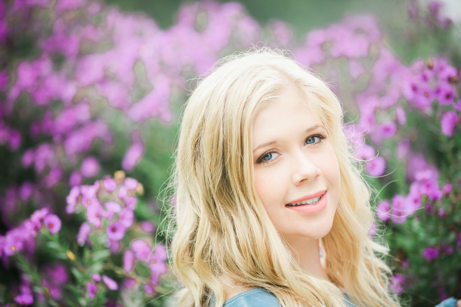 Portrait series among purple flowering bushes with soft natural lighting.