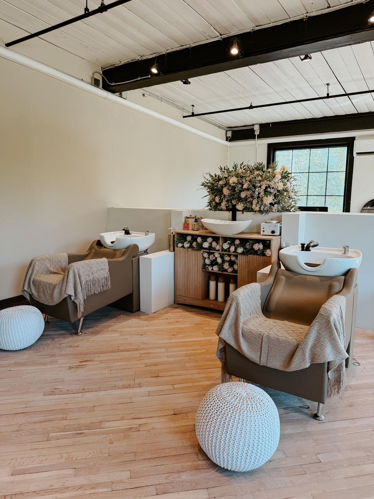 Luxury salon sink hair washing area at Wild In Bloom Beauty Co with modern boho decor and bridal flowers.