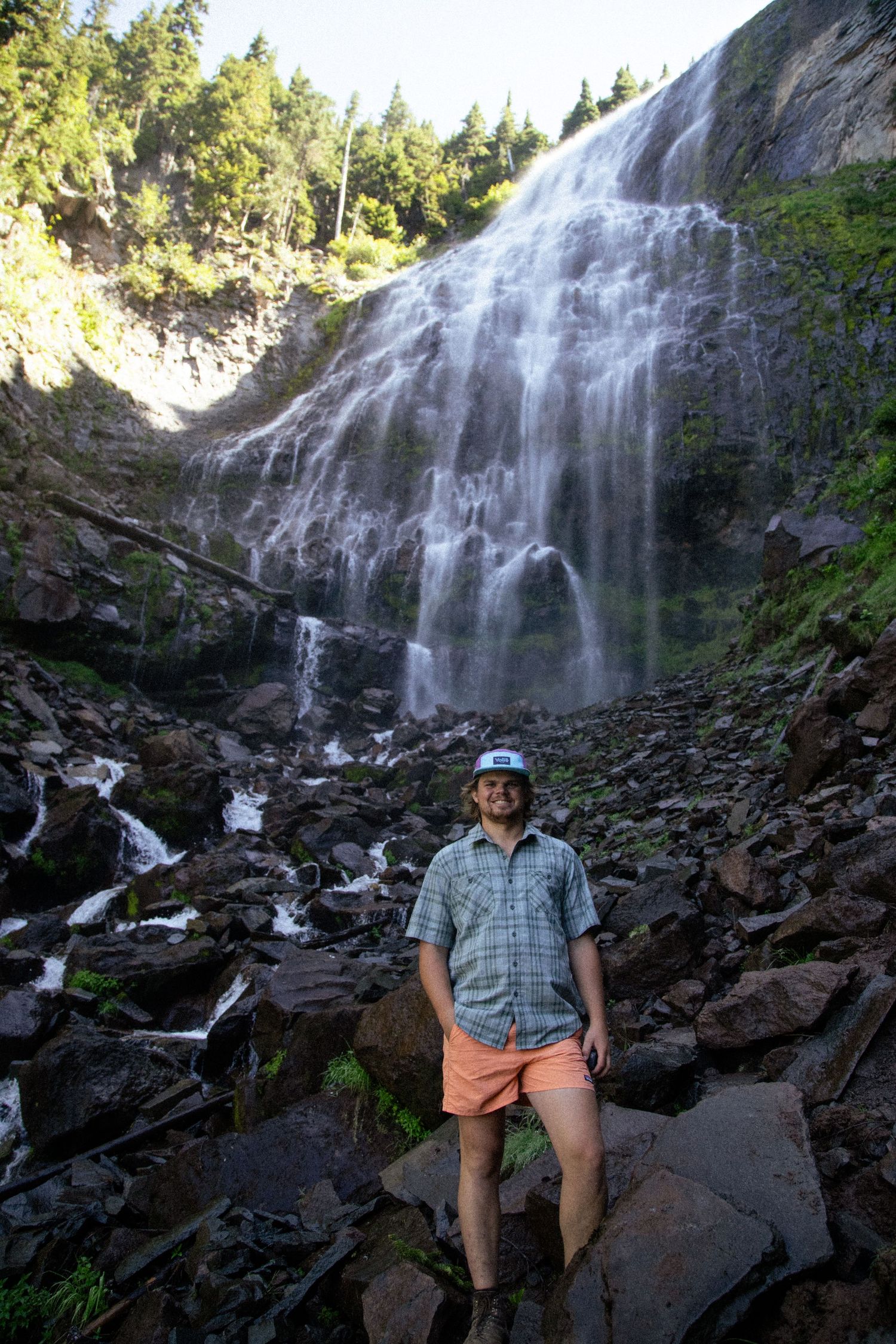 Husband poses at Waterfall in Mount Rainer national park
