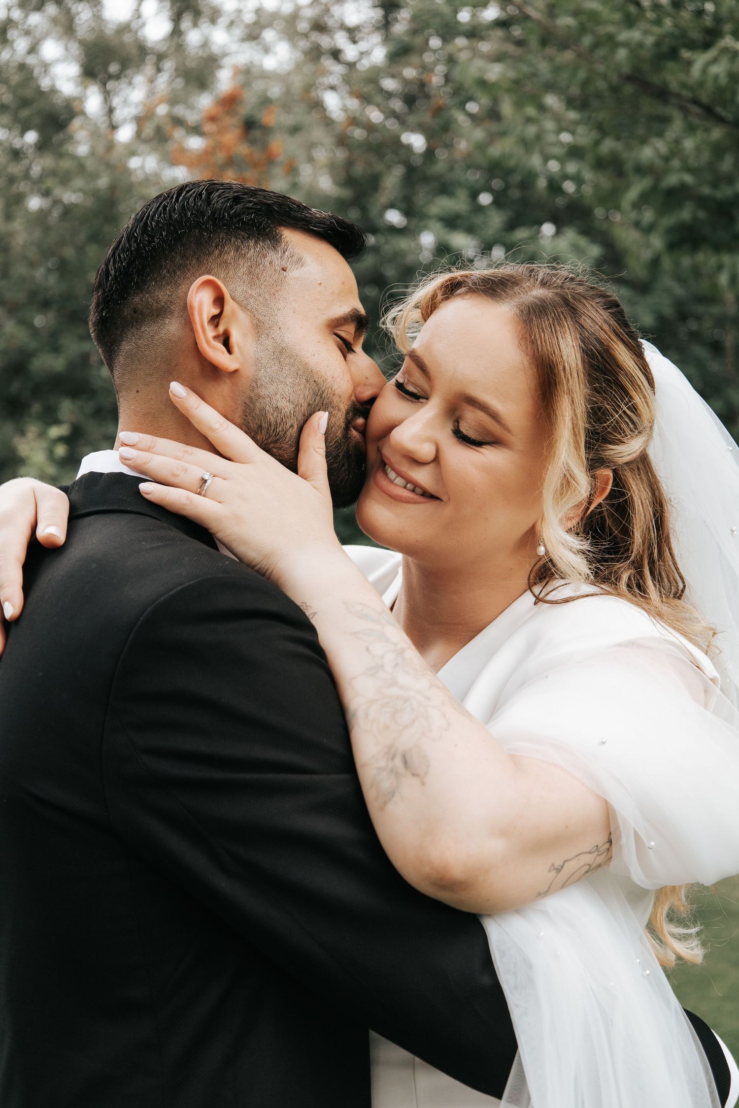 Intimate wedding portrait series showing tender moments between couple against natural backdrop.