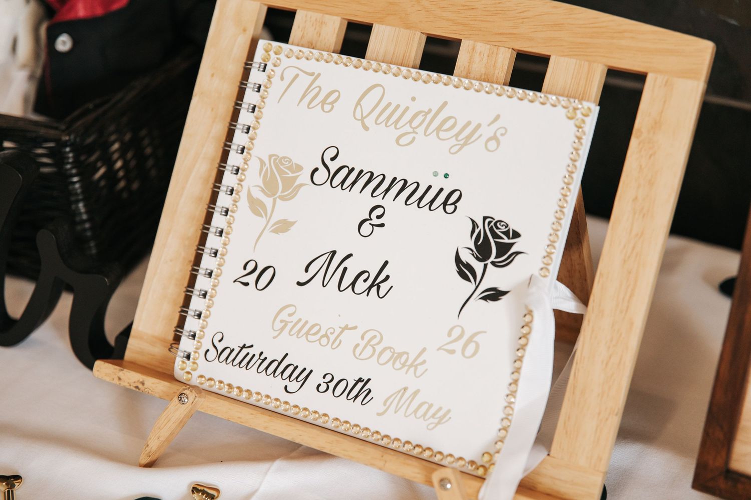 Personalized wedding guest book for The Quigleys, Sammie and Nick, Saturday 30th May, displayed on a wooden easel.