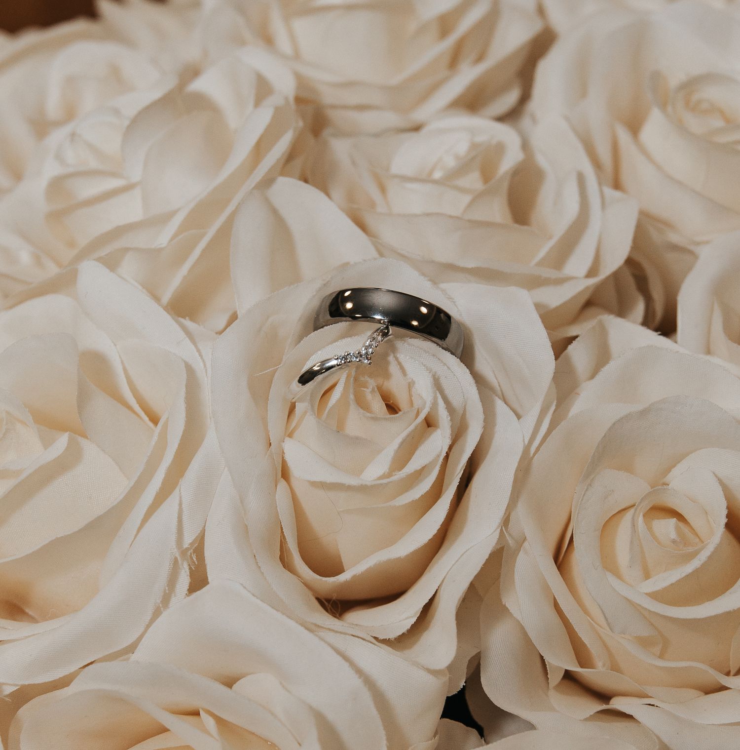 Elegant cream-colored roses arranged in a textured wall display for wedding decor.
