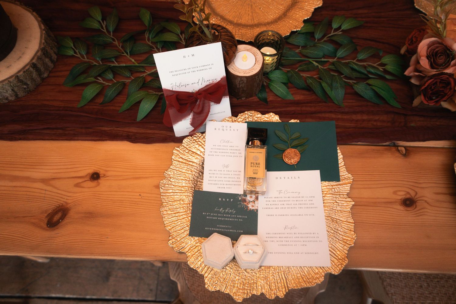 Flat lay of wedding stationery with greenery and doilies on wooden background.