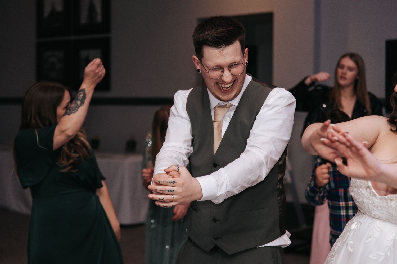 Wedding reception guests dancing and celebrating on the dance floor.