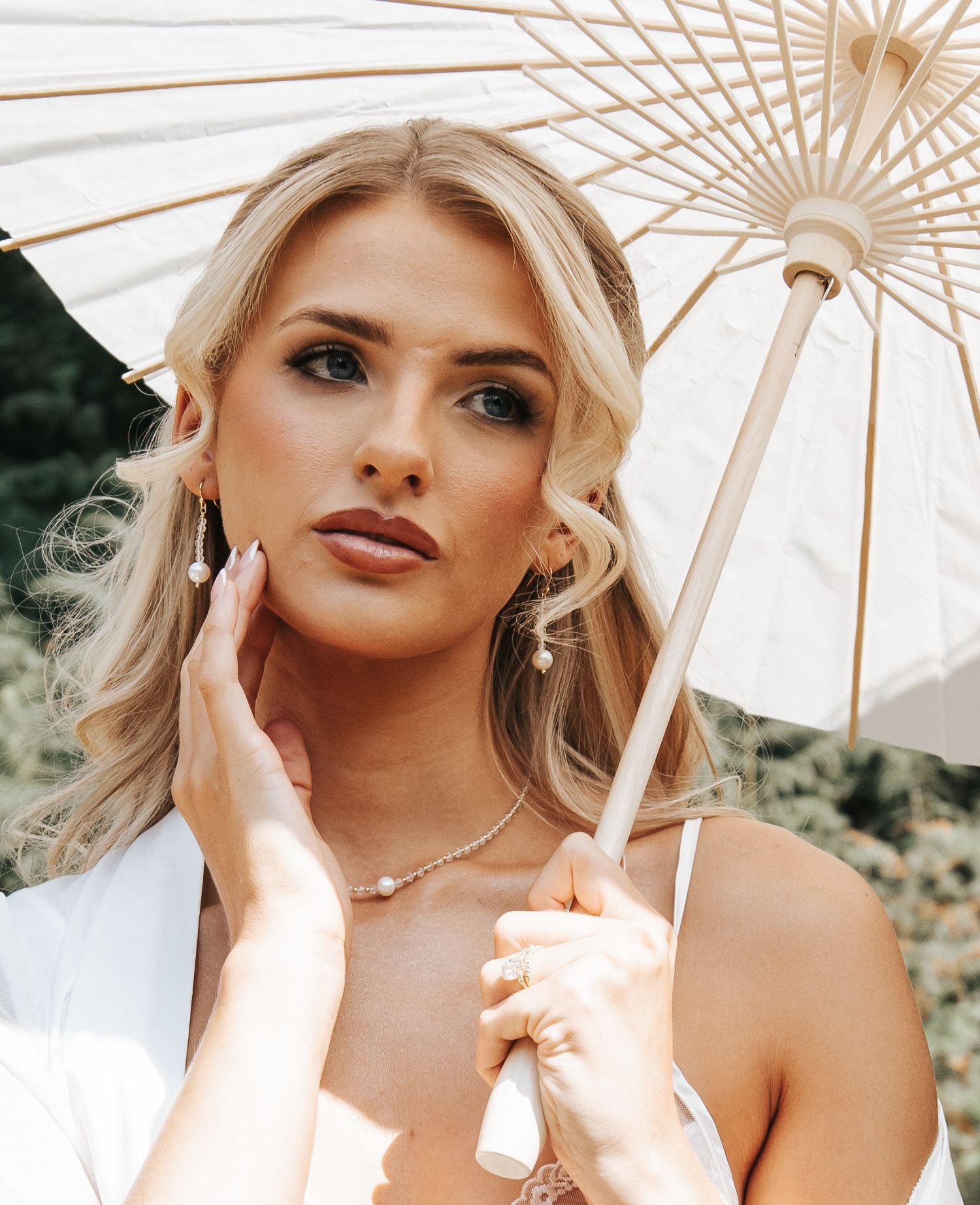 Elegant portrait series featuring decorative parasol and delicate jewelry styling.