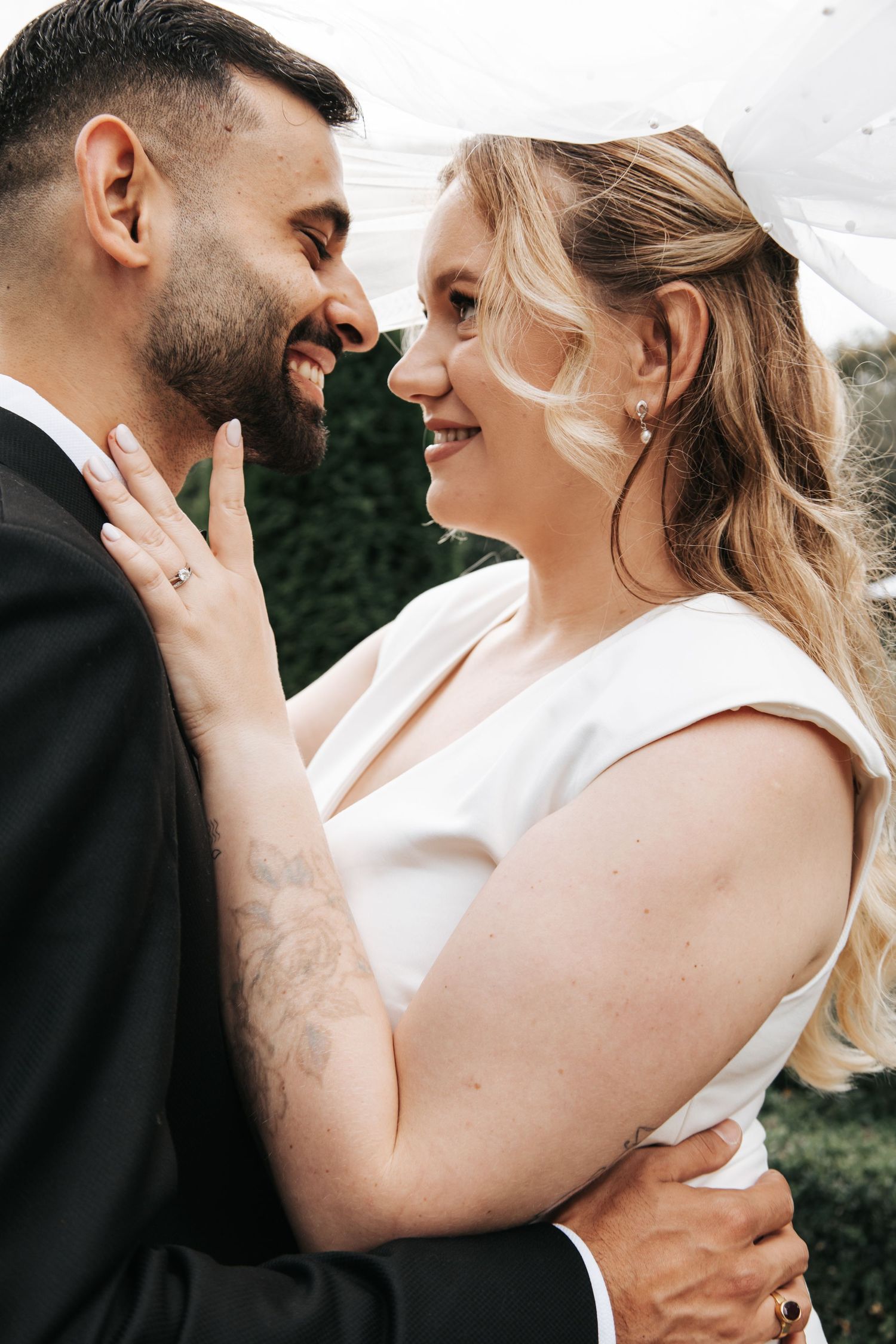 Close-up shots of a tender moment between newlyweds in white dress and black suit.