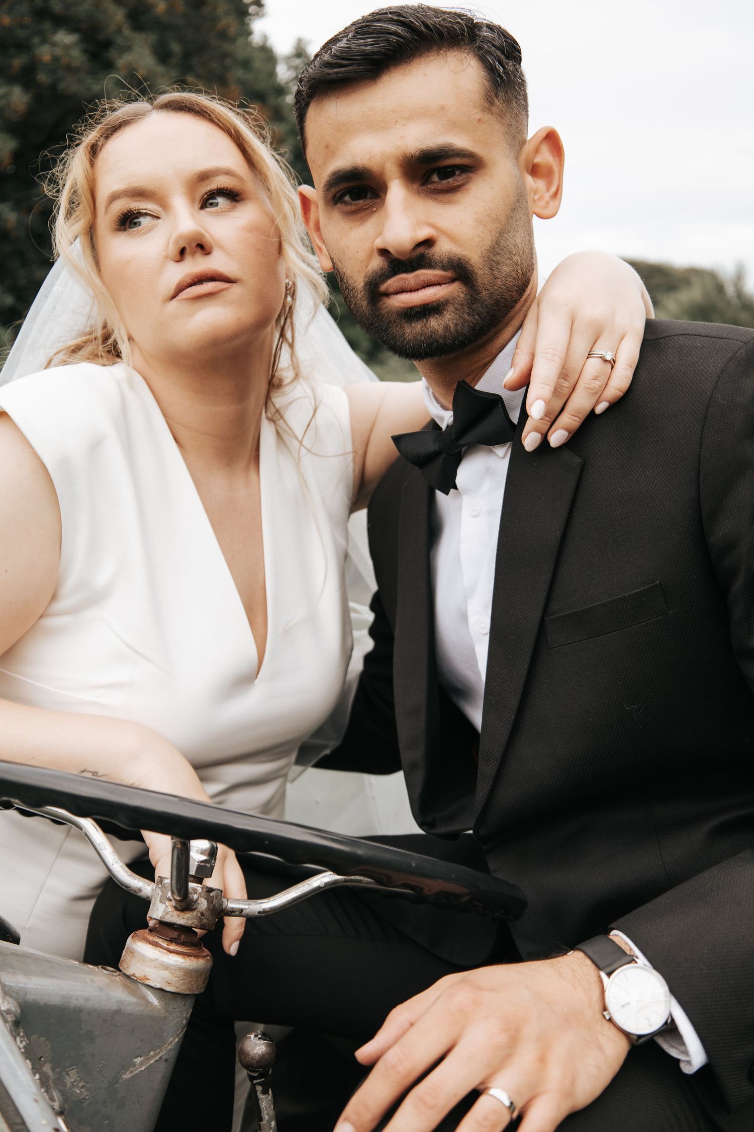 Romantic wedding couple poses together in elegant black and white formal attire.