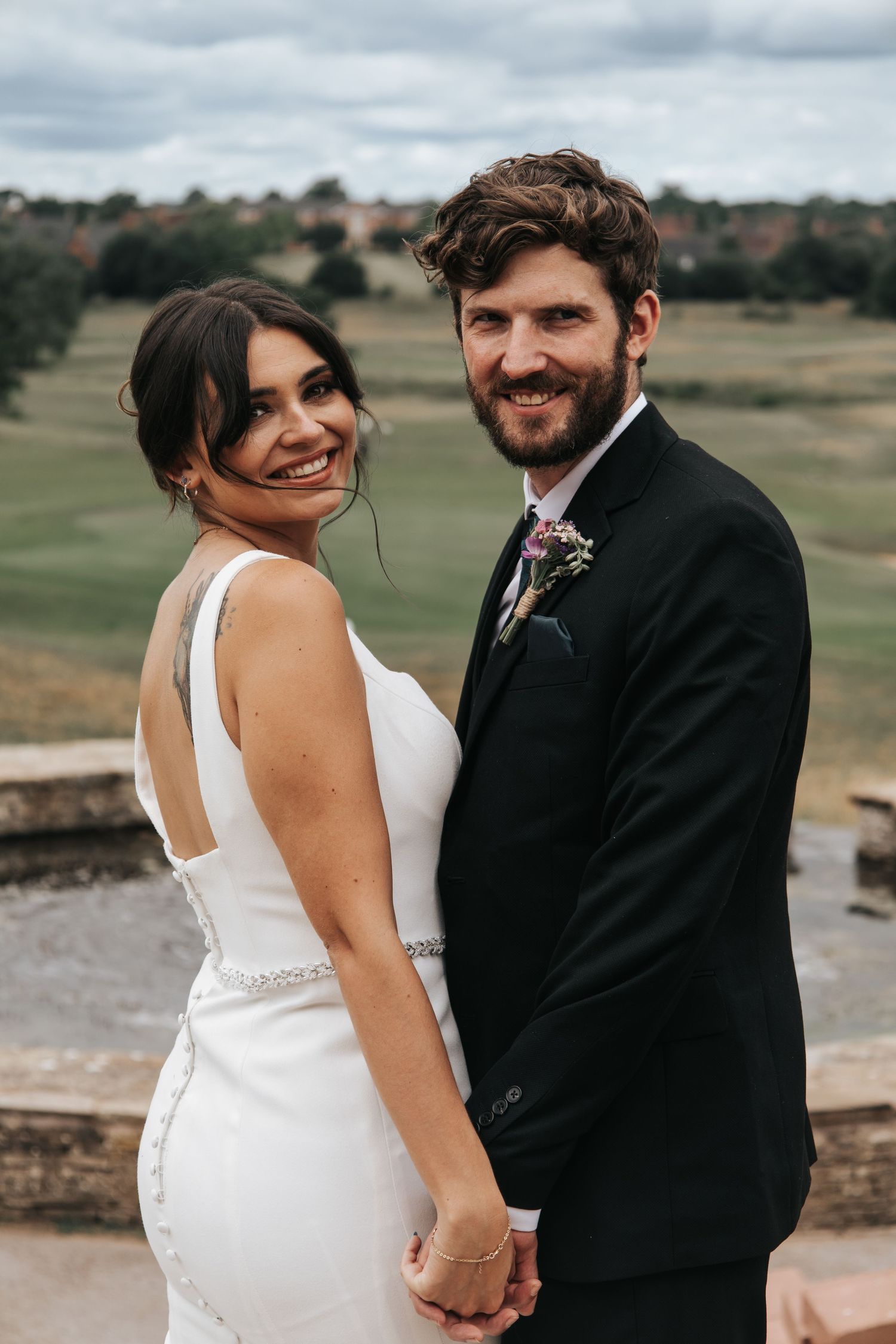 Happy newlyweds share joyful moments together on an outdoor terrace.
