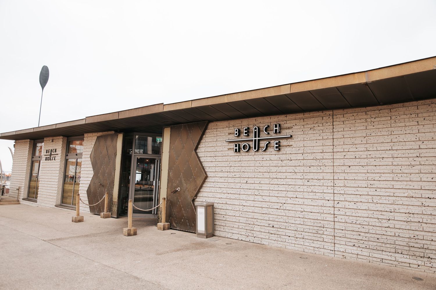 Exterior of Stitch House building with white brick walls and modern signage in an urban setting.