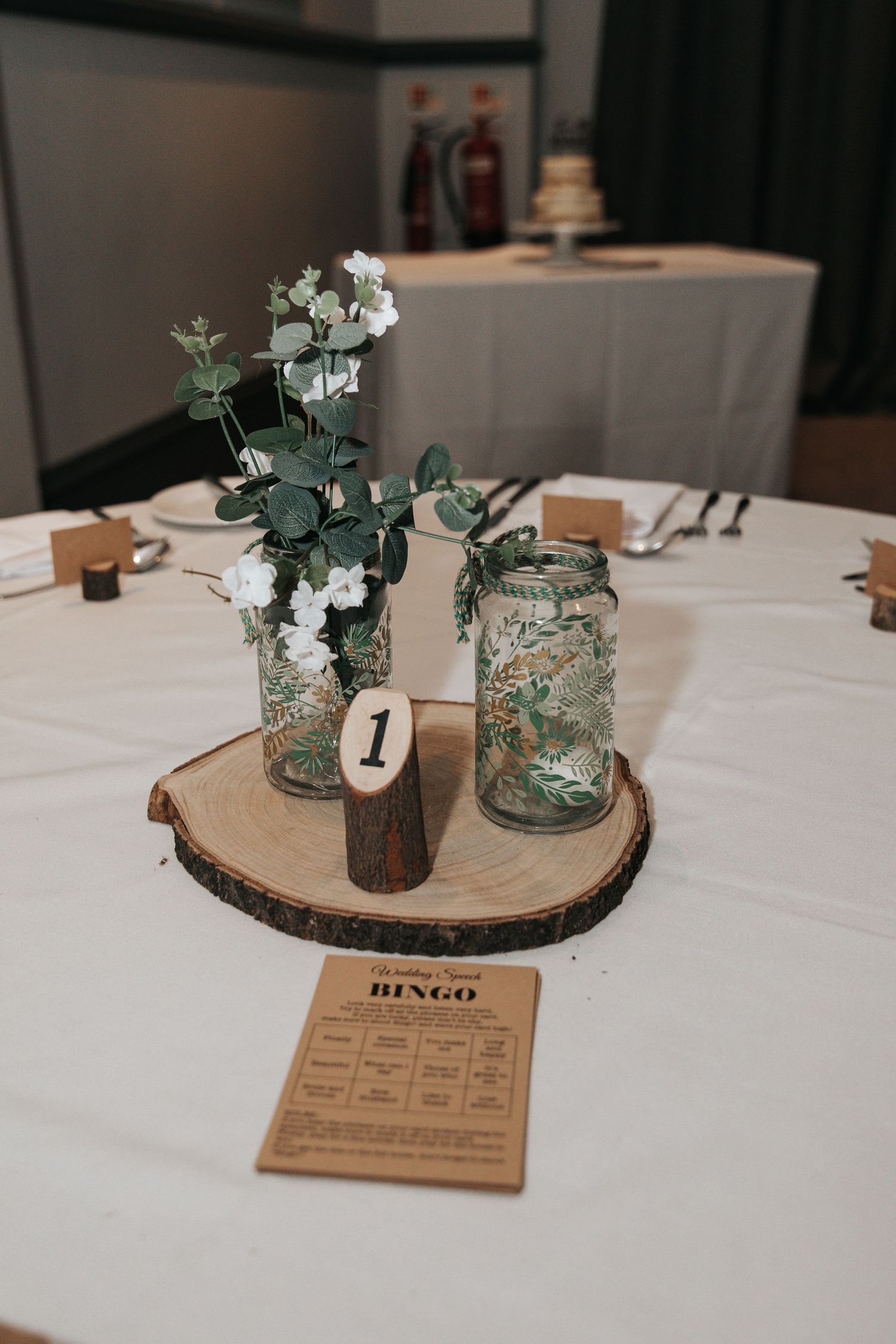 Rustic wedding table centerpieces featuring wood slices, mason jars, and delicate floral arrangements.