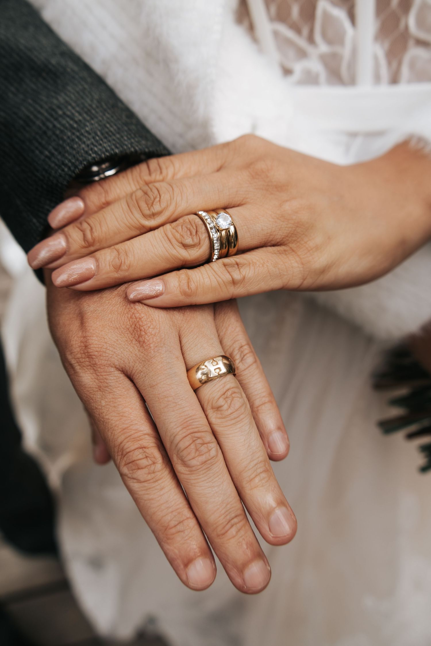Close-up of wedding rings and hands showing detailed wedding day jewelry.