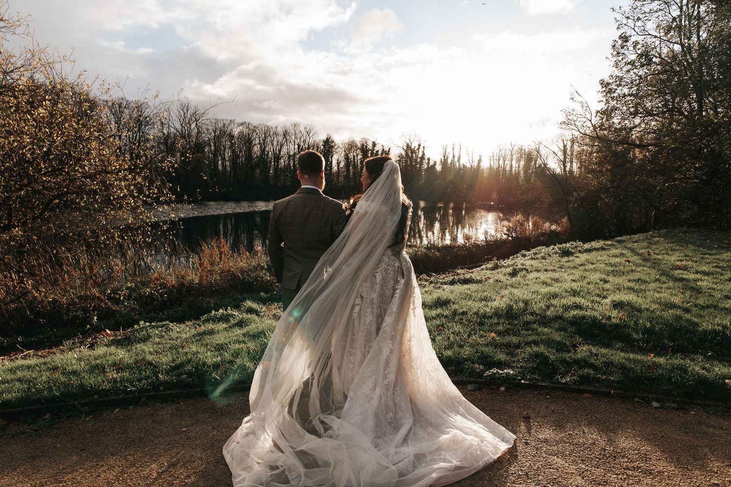 Sunset wedding photo with bride's dress flowing in the wind.