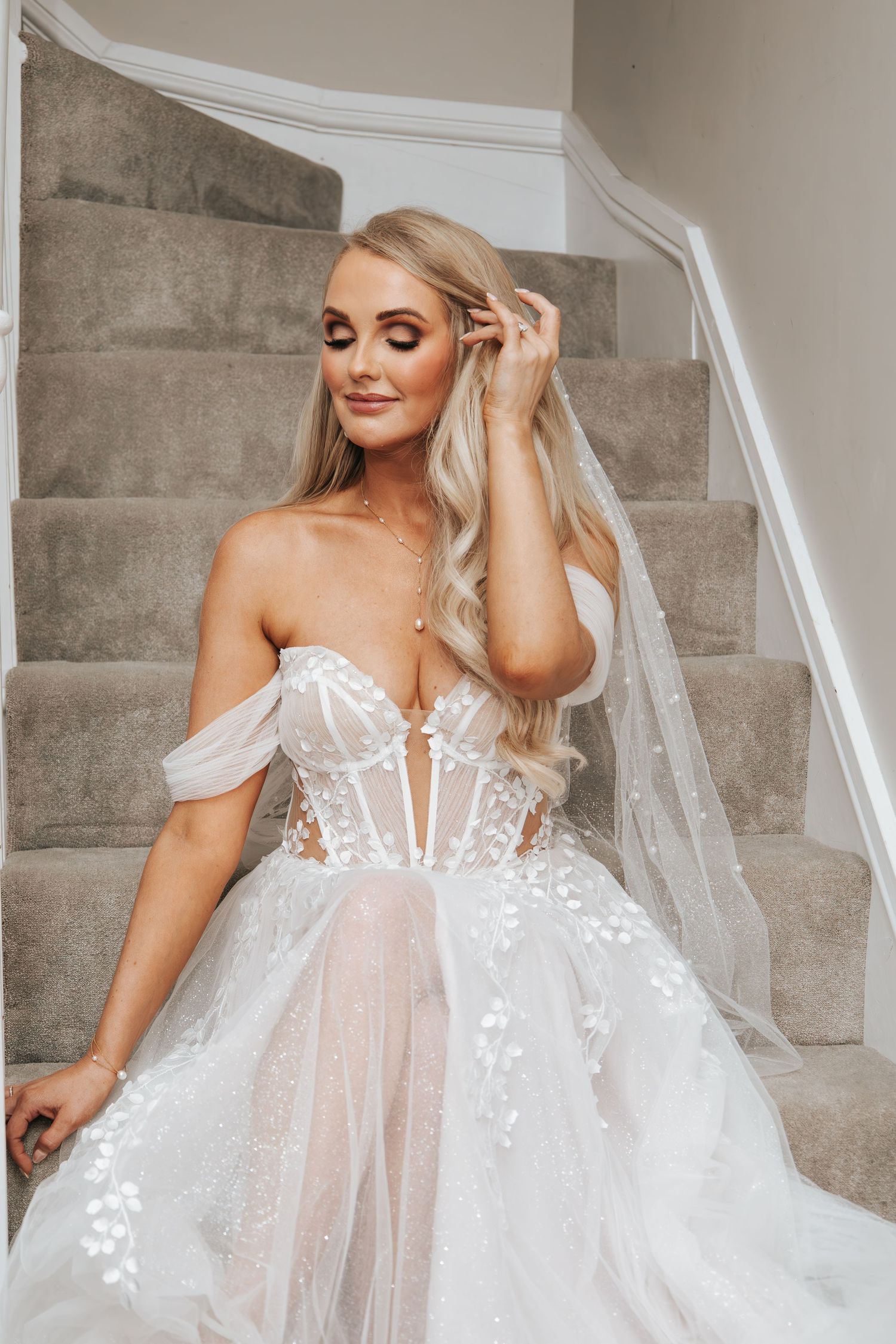 Close-up of a wedding dress featuring delicate lace details and off-shoulder design.