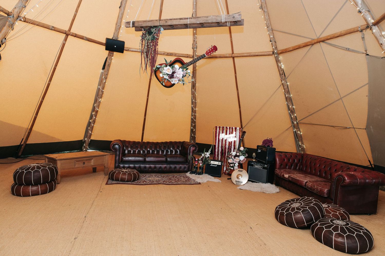 Interior view of a tipi-style tent with leather seating and musical instruments.
