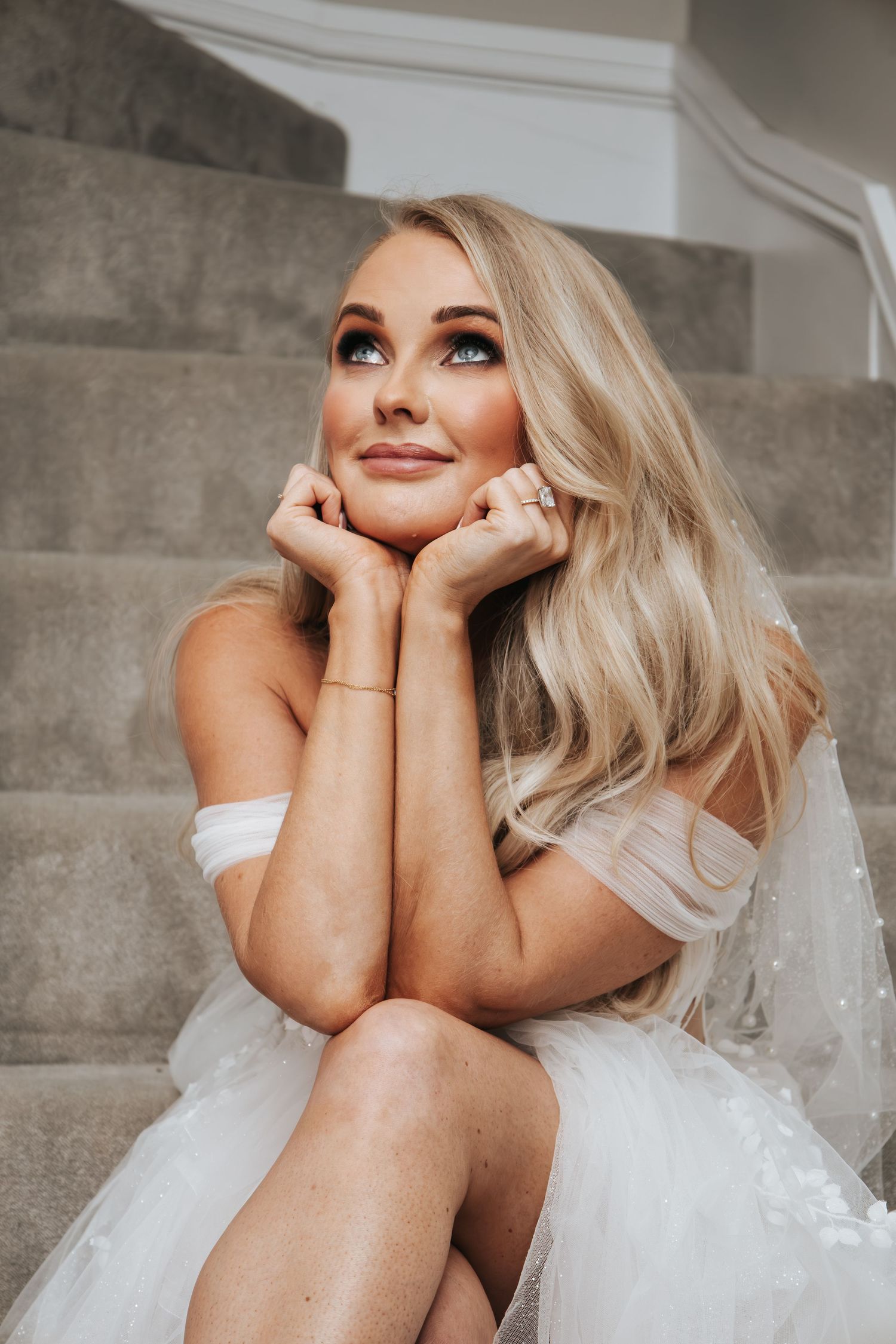 Intimate bridal portrait on concrete stairs showing elegant makeup and hair styling.