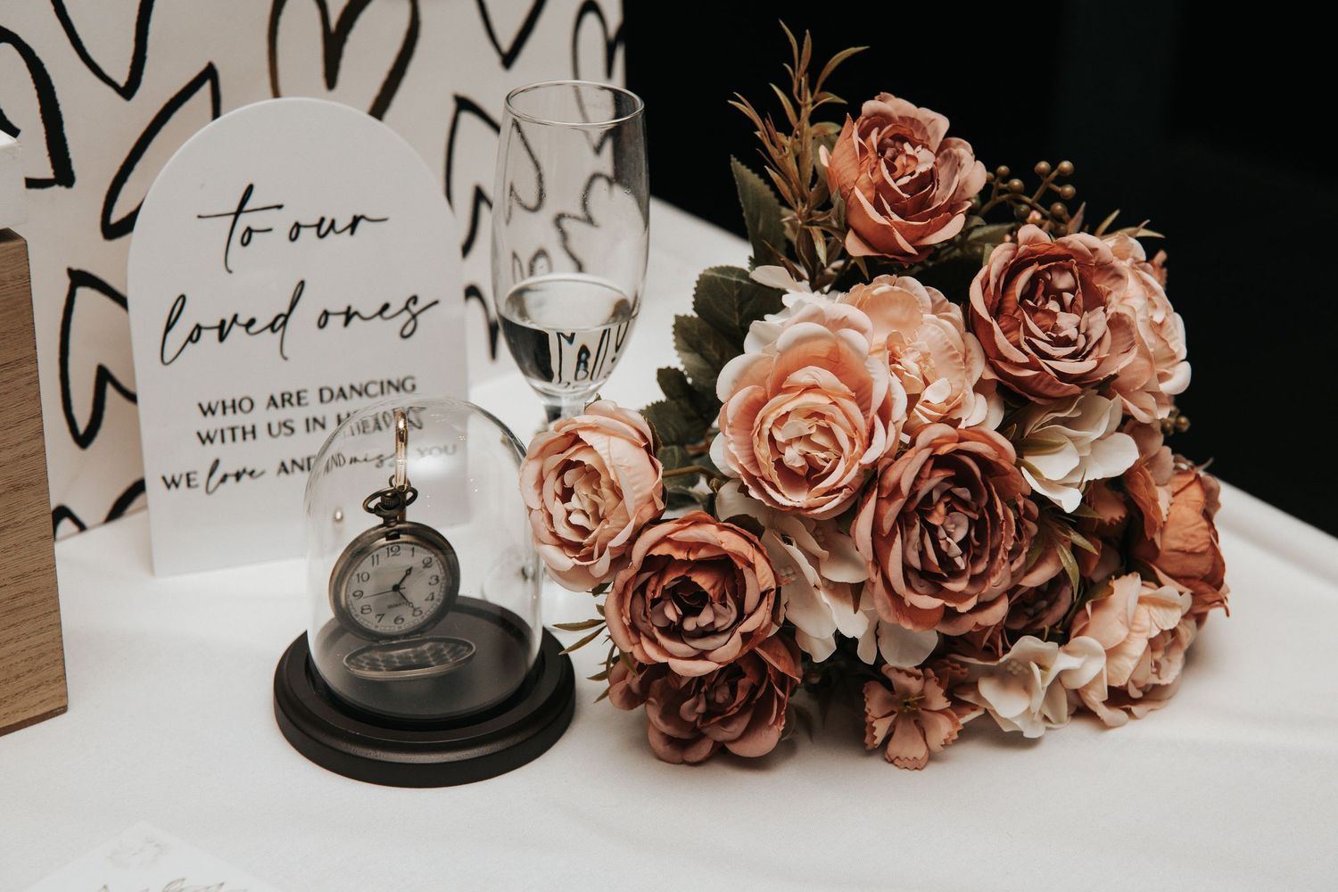 Wedding decor featuring dusty rose flowers and romantic message cards on a dark background.