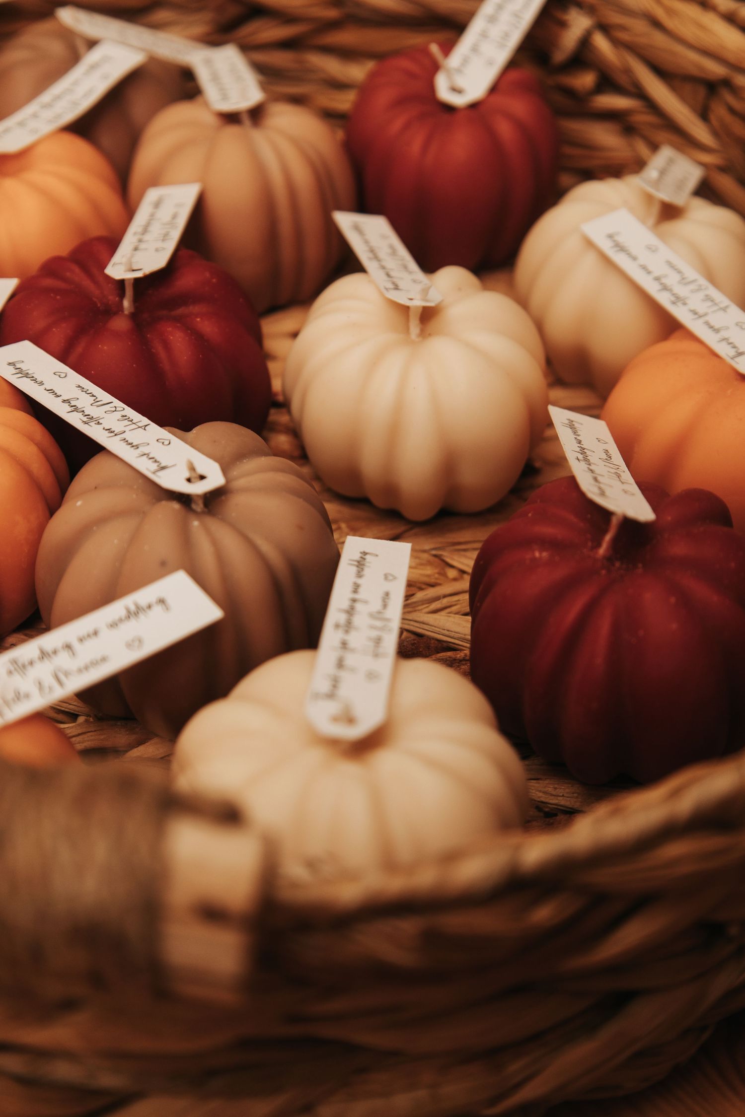 Autumn-themed decorative pumpkins in shades of burgundy and cream with small paper tags attached.