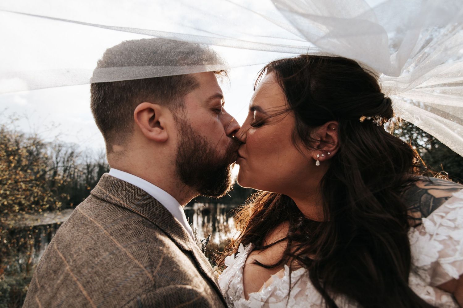 Romantic wedding couple sharing tender moments during outdoor photo session.