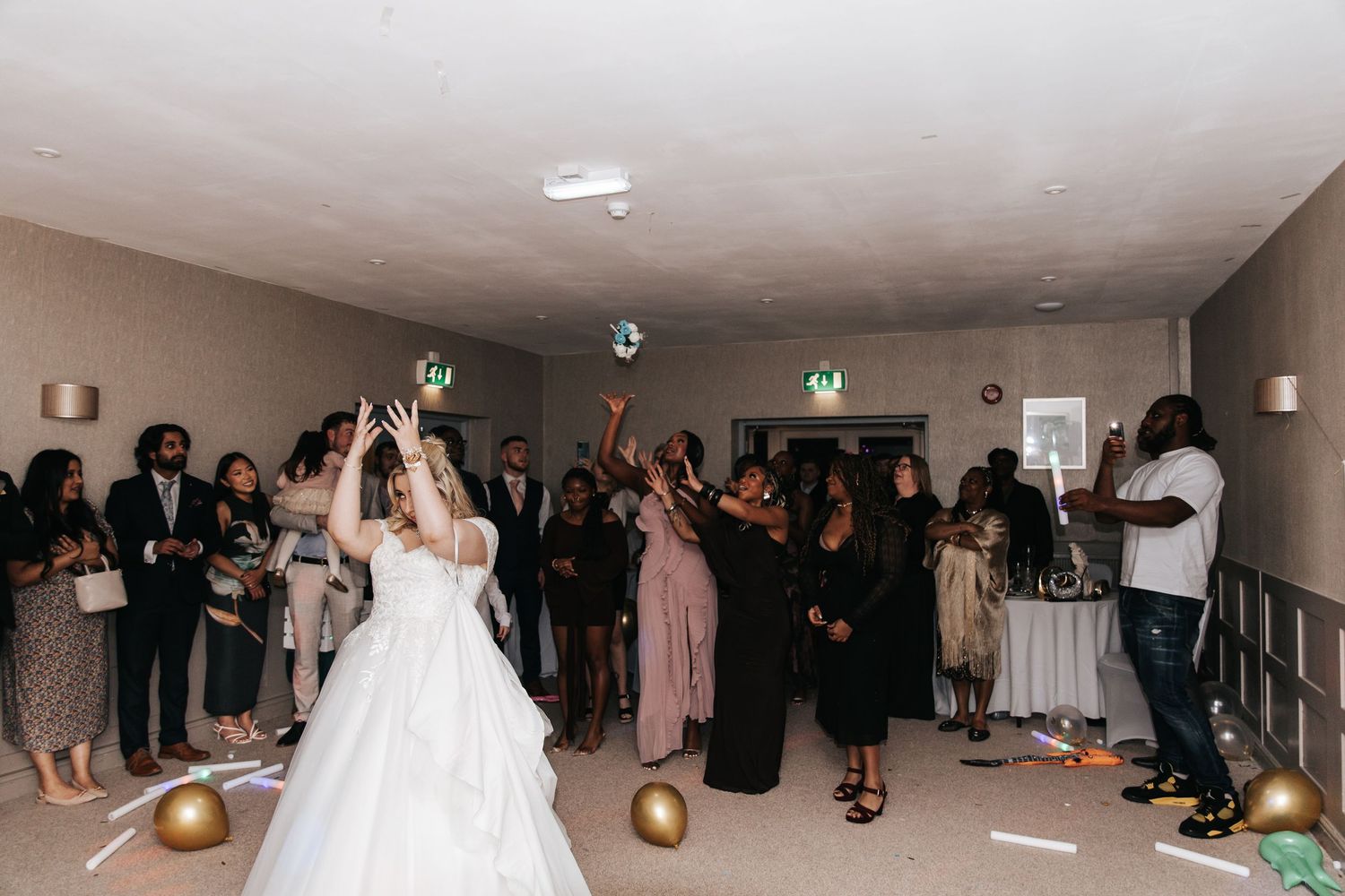 Wedding guests enjoying themselves on a dance floor during a celebration.
