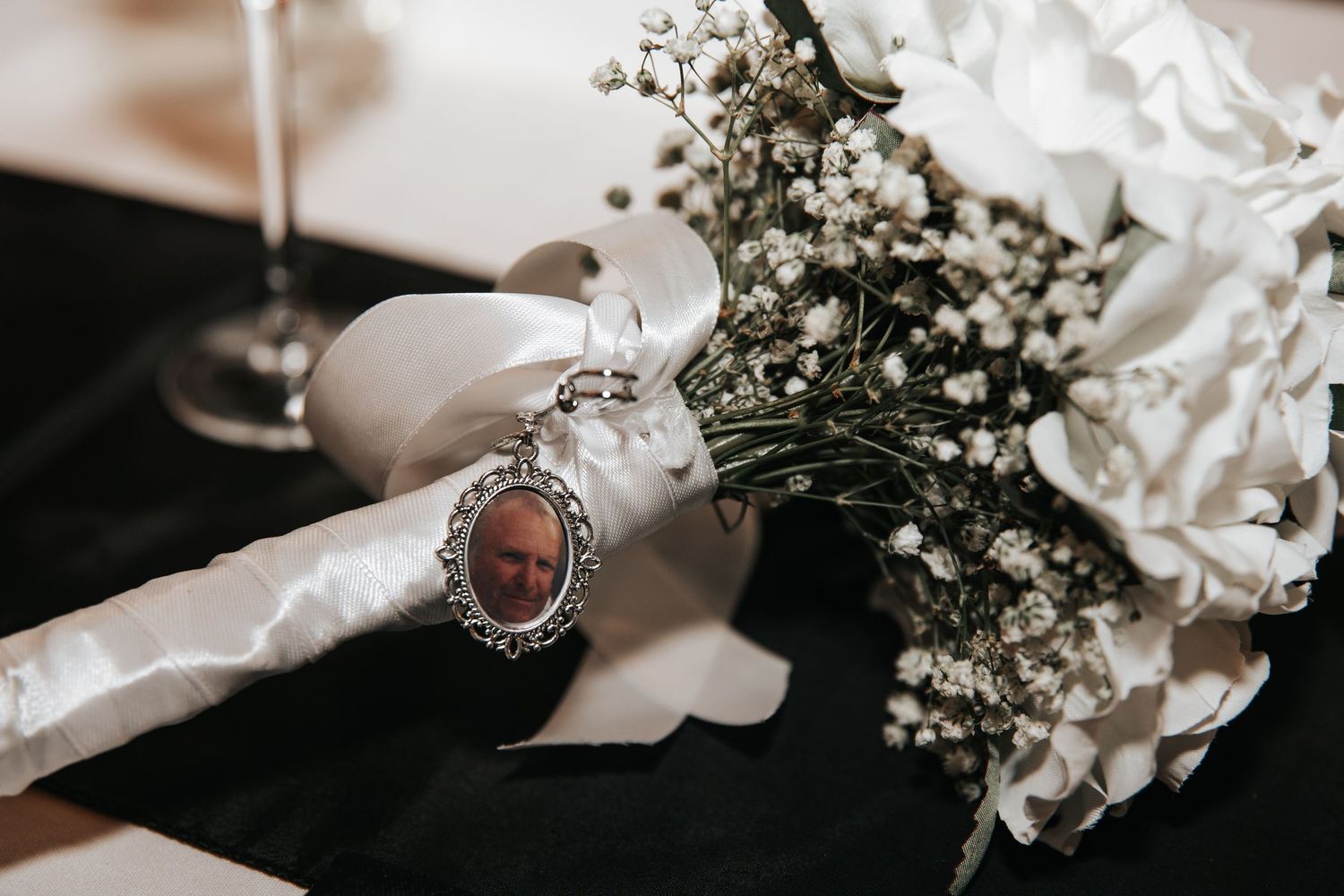 Wedding details with baby's breath flowers, rings, and vintage-style accessories in monochrome.