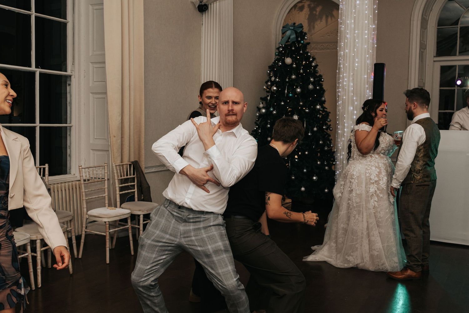 A collection of black and white wedding photos showing couples dancing and embracing at an elegant indoor reception venue.