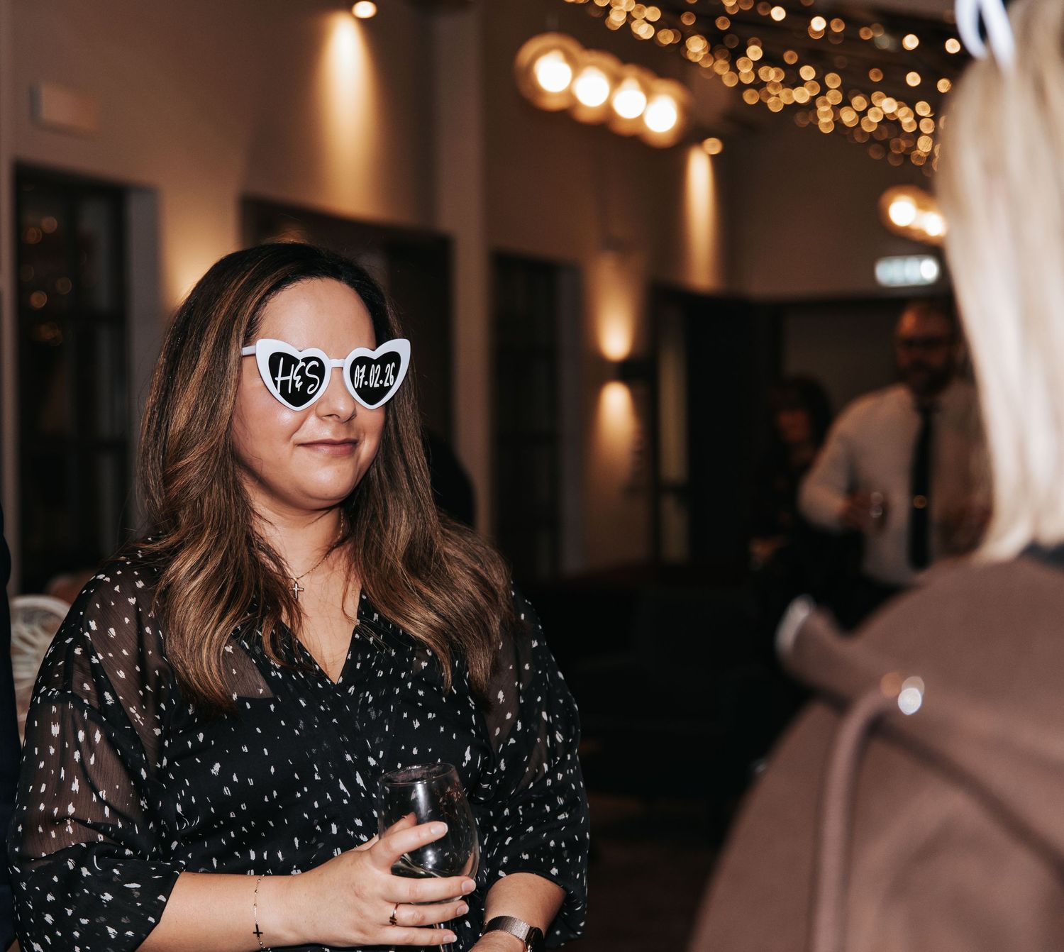 A sequence of candid party photos showing people in a dimly lit venue with warm lighting and string lights in the background.