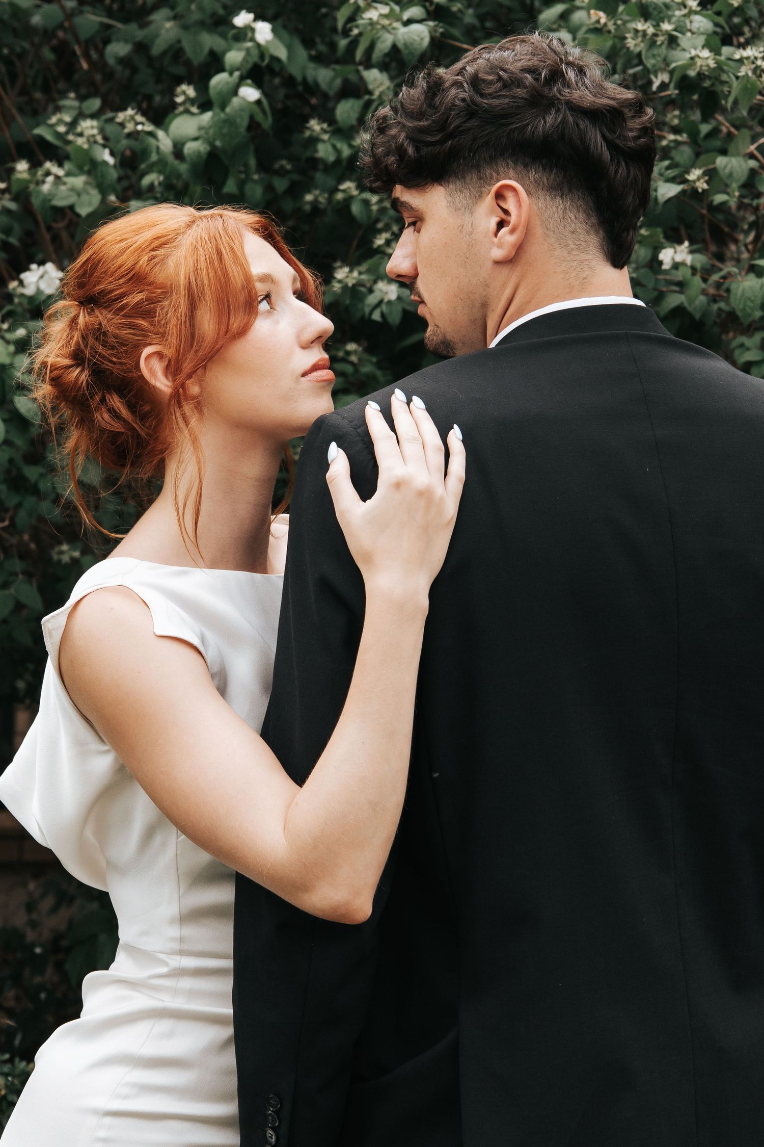 Intimate wedding portraits against lush green garden backdrop.