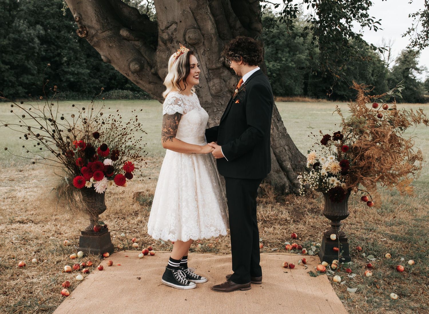 Wedding ceremony setup with floral arrangements and guests on an outdoor path.