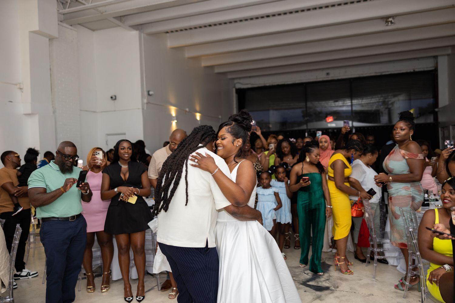 Wedding guests dancing and enjoying themselves on a crowded dance floor during a reception celebration.